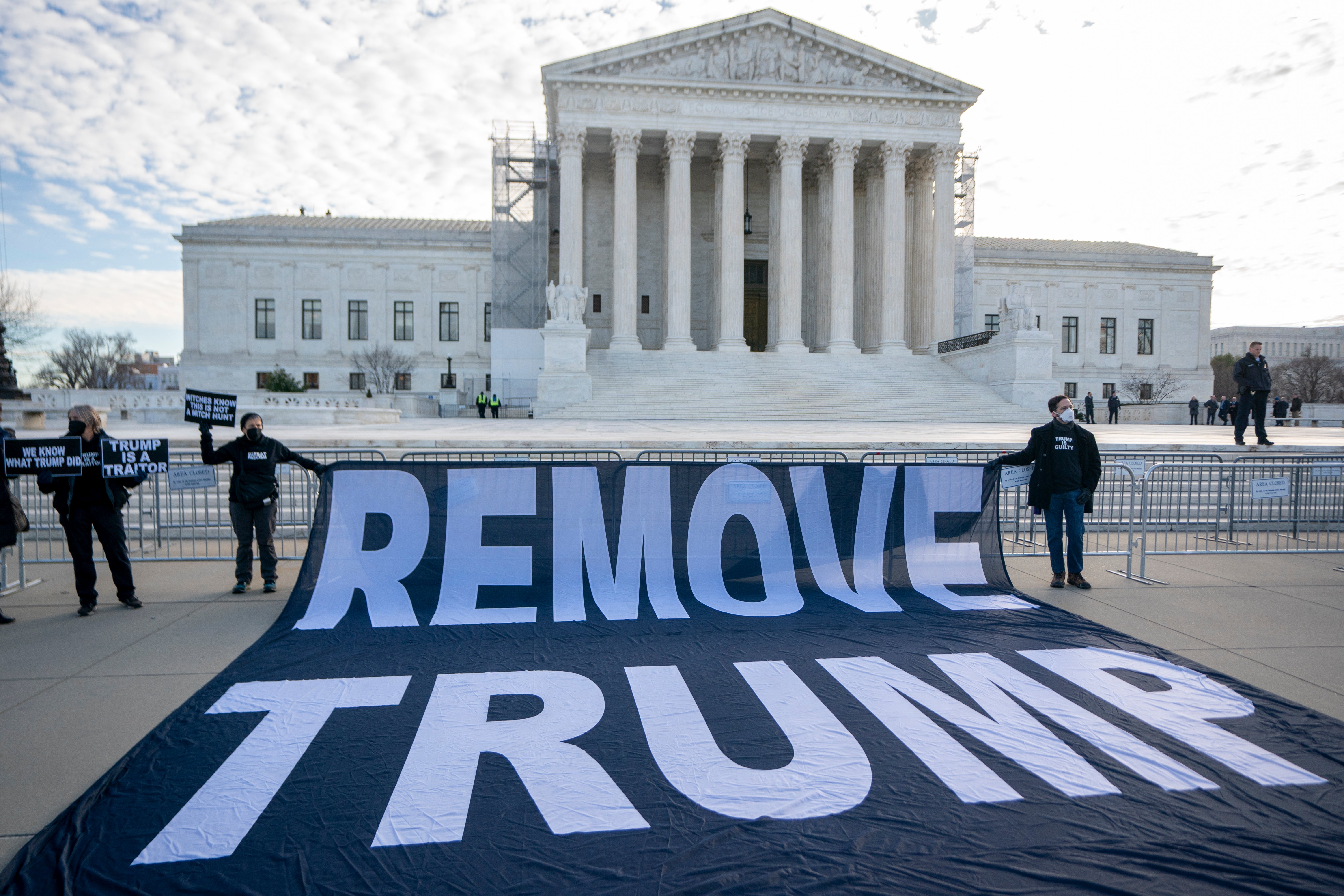 Protesters hold a ‘remove Trump’ banner outside the US Supreme Court on 8 February as justices hear arguments in case considering whether to disqualify the former president from office.