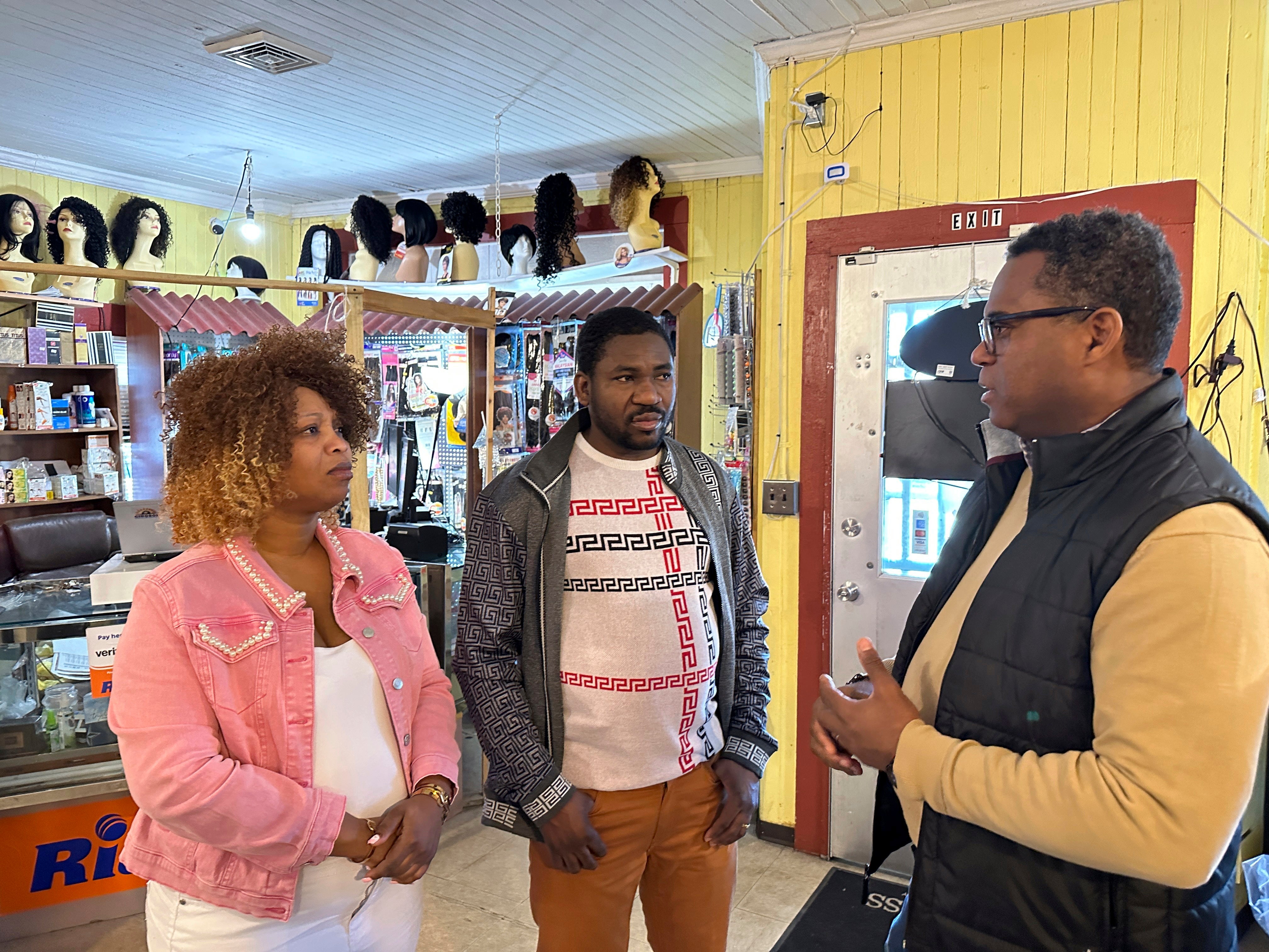 Clemene Bastien and Theslet Benoir talk with Pastor Calherbe Monel inside Bastien and Benoir’s Eben-Ezer Variety Market