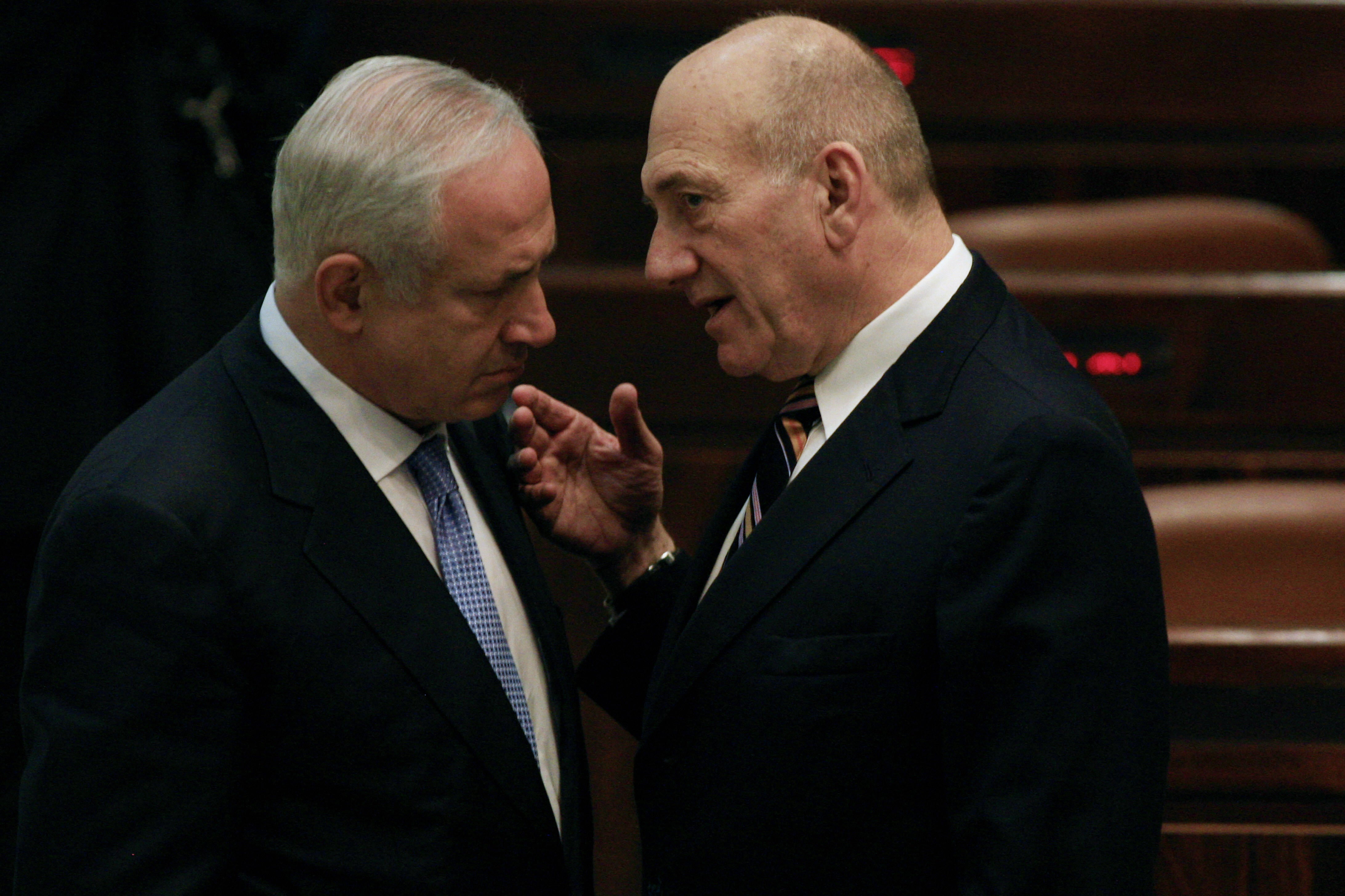 Former Israeli prime minister Ehud Olmert, right, speaks to Benjamin Netanyahu before his swearing-in