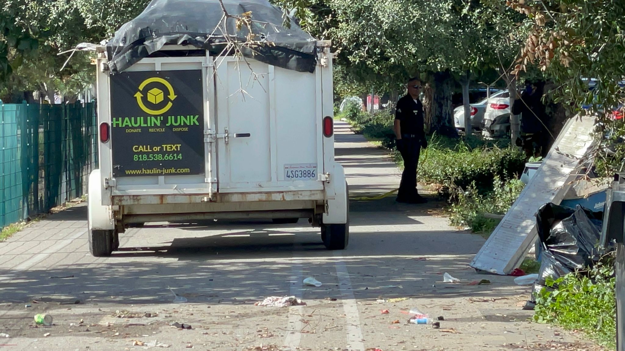 LAPD officers and sanitation workers remove an encampment on Friday after the storms