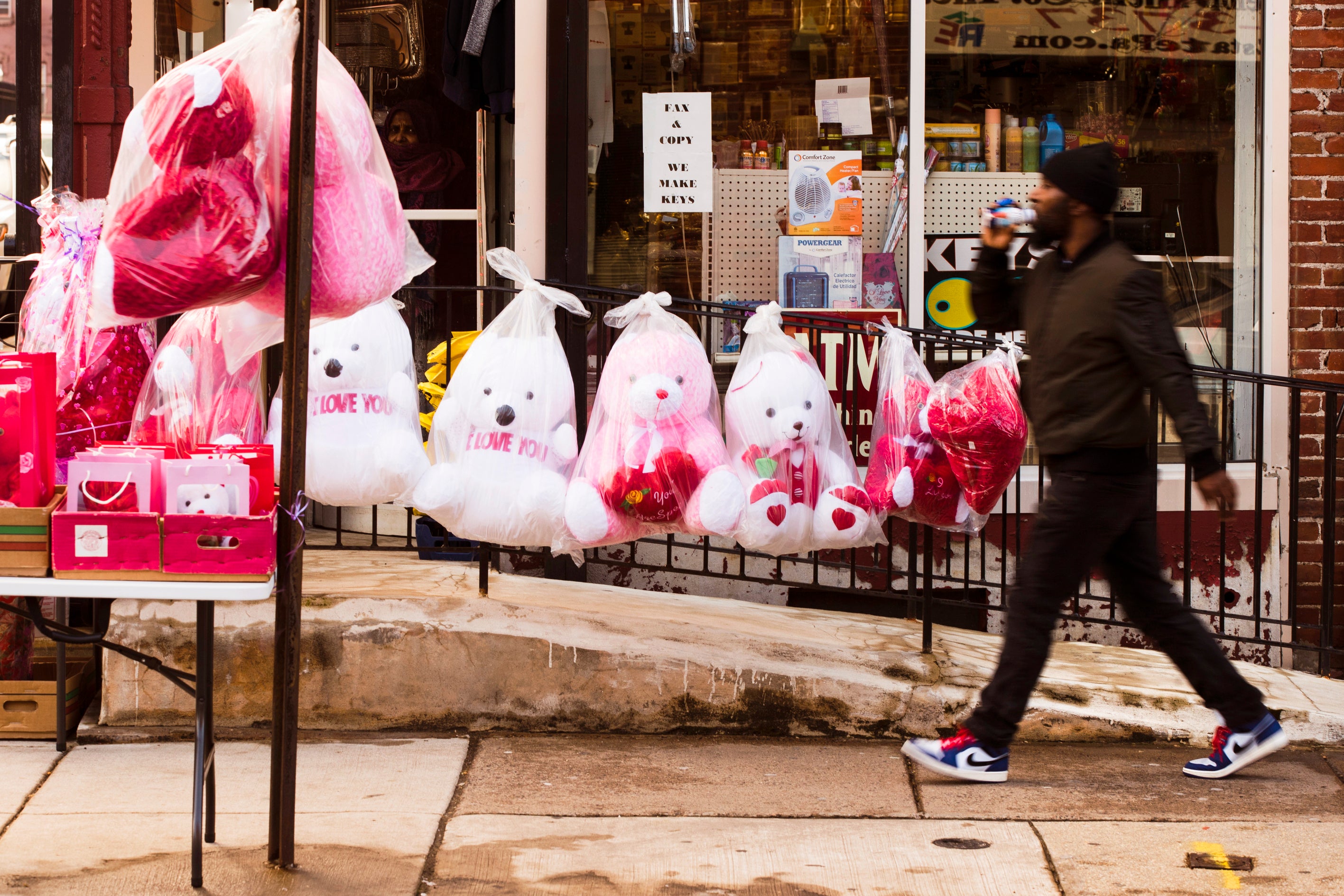 A pedestrian passes Valentine’s day stuffed animals for sale