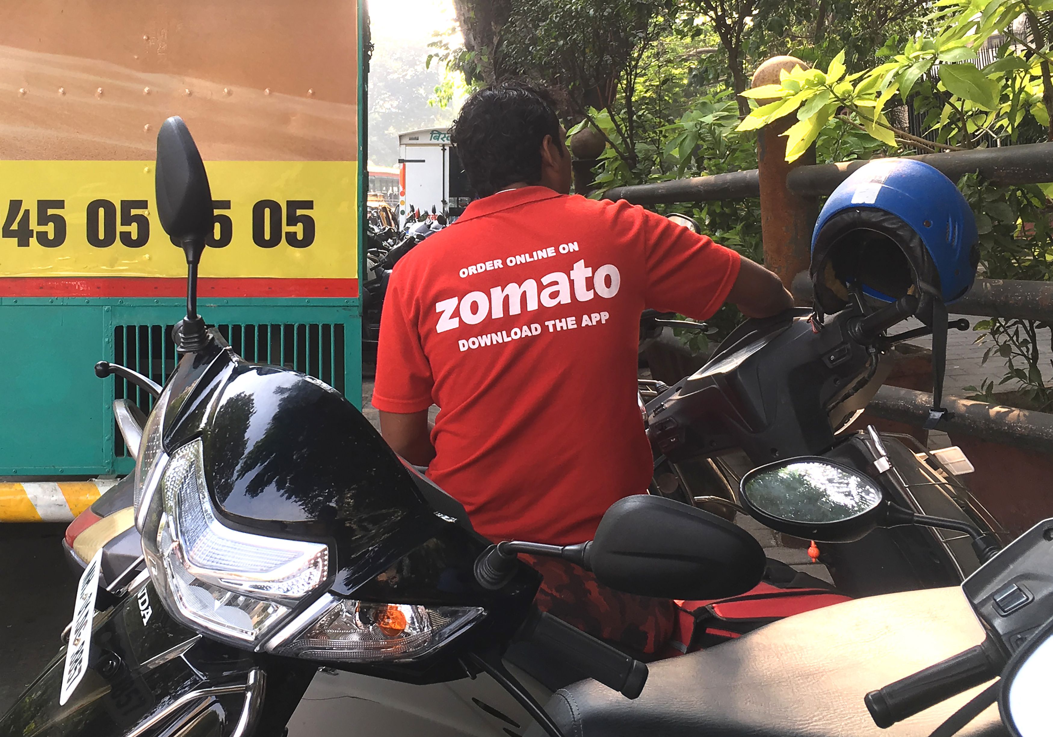 In this photo taken on 24 December 2018, an Indian delivery man working with the food delivery app Zomato sits on his bike in a business district in Mumbai.