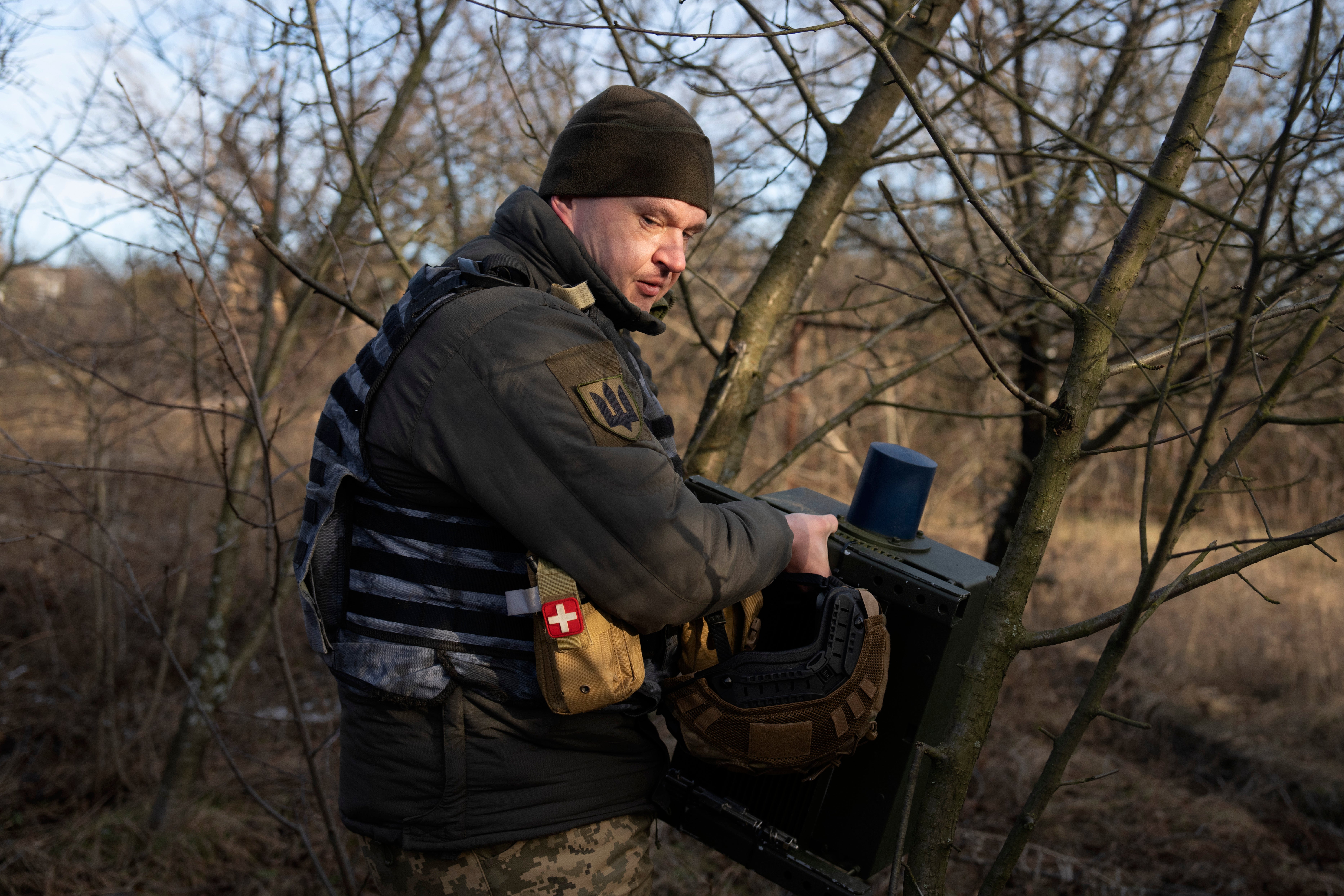 A Ukrainian soldier installs an electronic warfare system to quell Russian drones at the front line