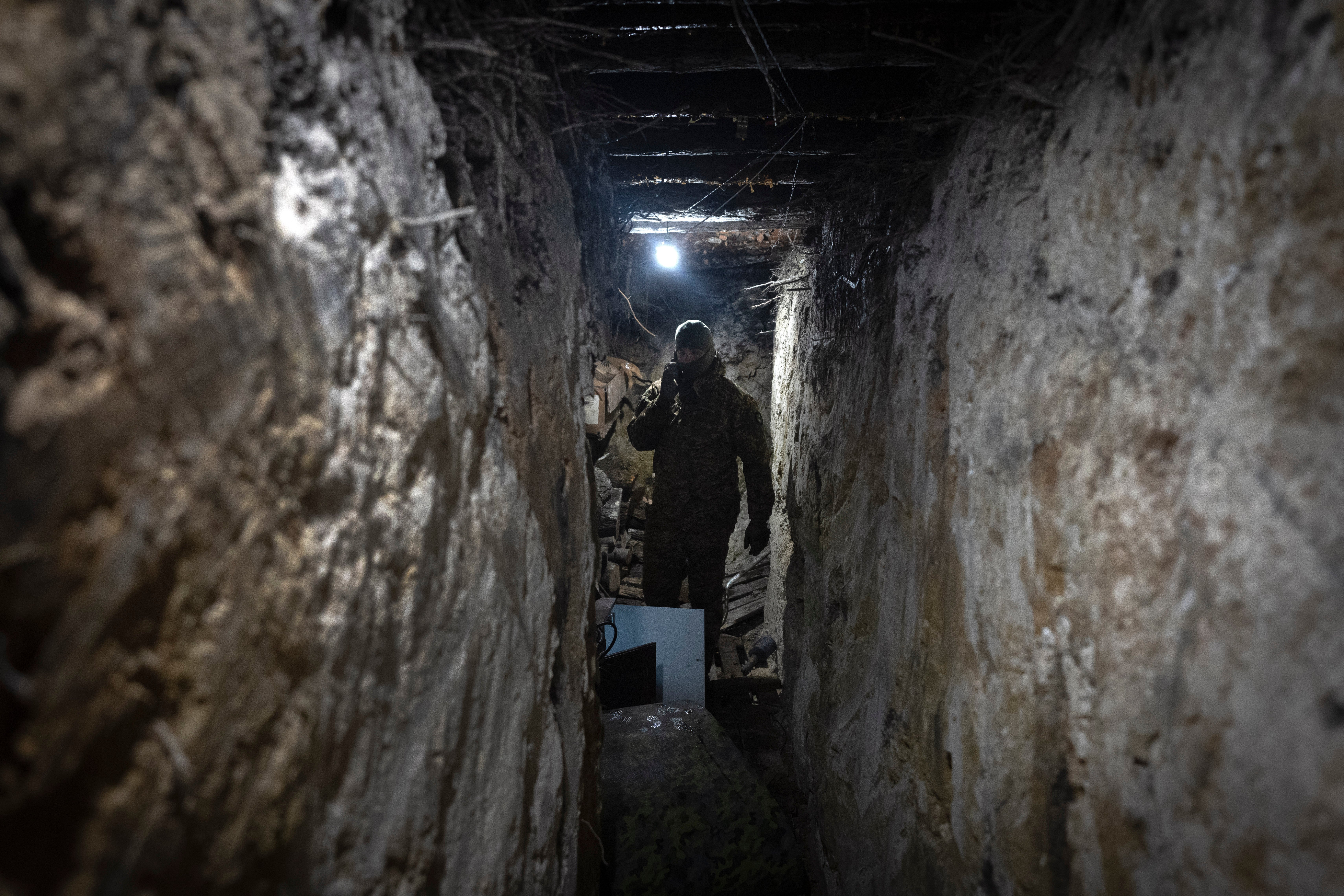 A Ukrainian soldier works with an electronic warfare system to listen to Russian chatter in a shelter at the front line