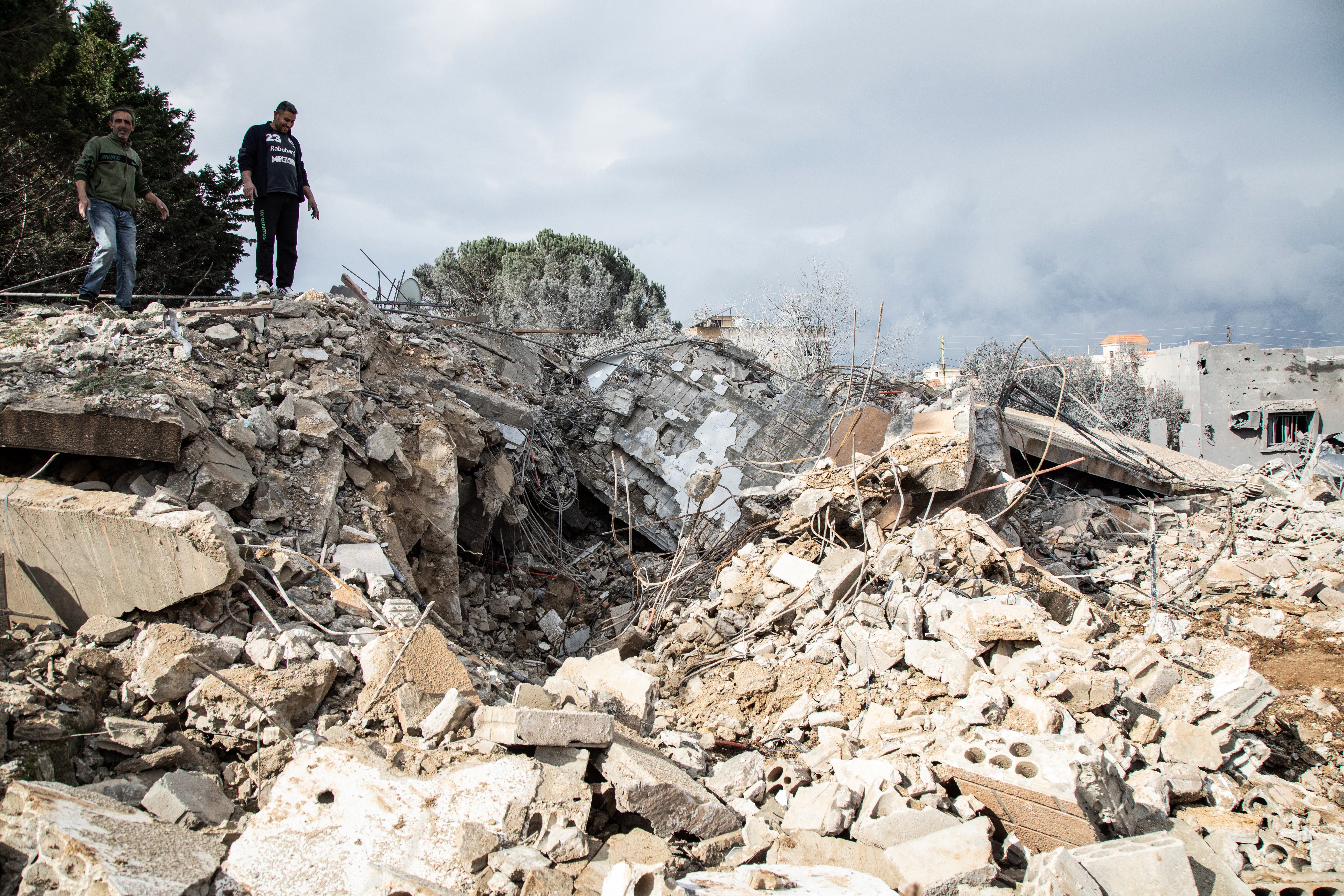 Men check the destruction following an Israeli airstrike the previous day on the village of Taybeh near the border with Israel in southern Lebanon, on 15 February 2024