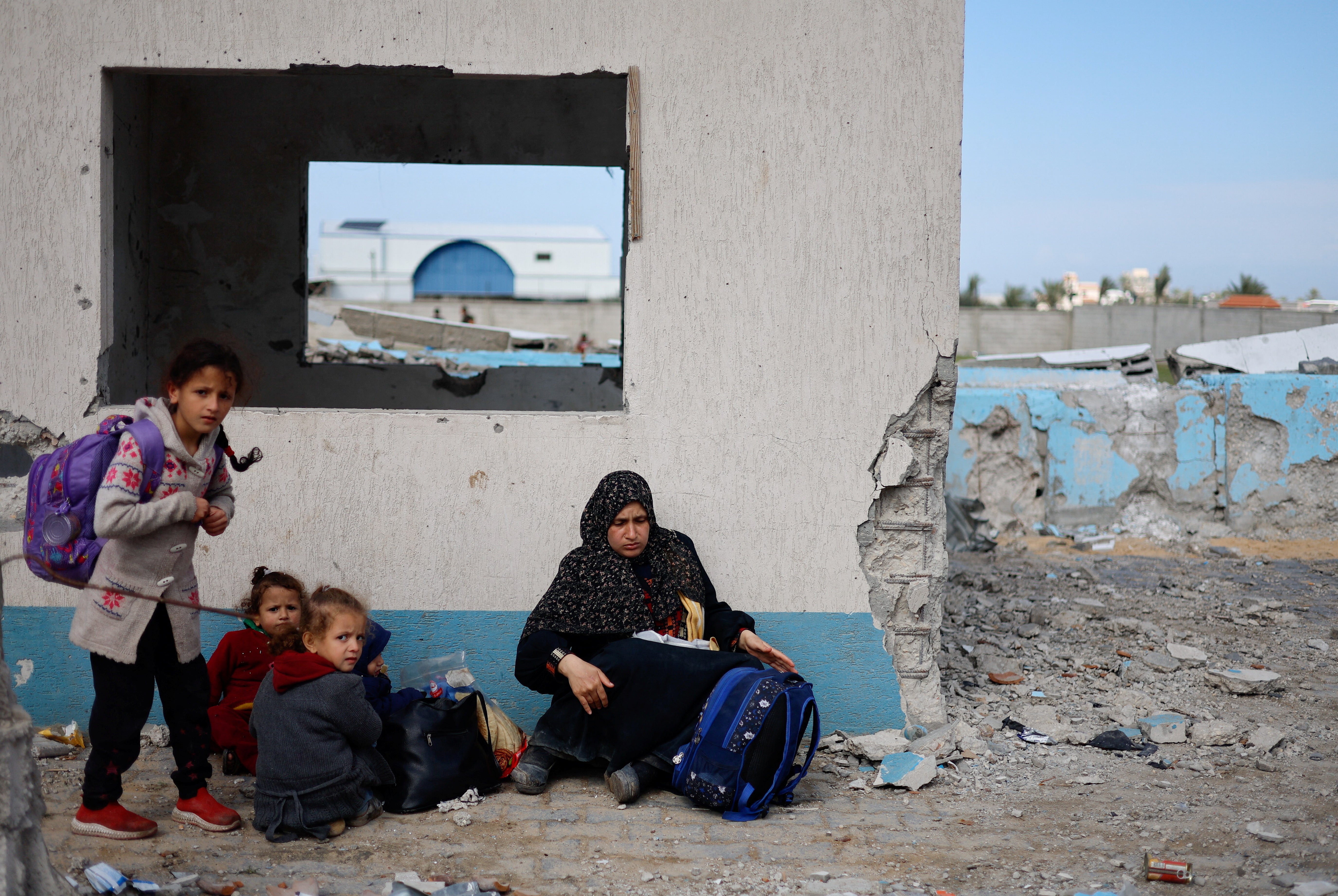 A woman rests with children, as Palestinian arrive in Rafah after they were evacuated from Nasser hospital in Khan Younis due to the Israeli ground operation