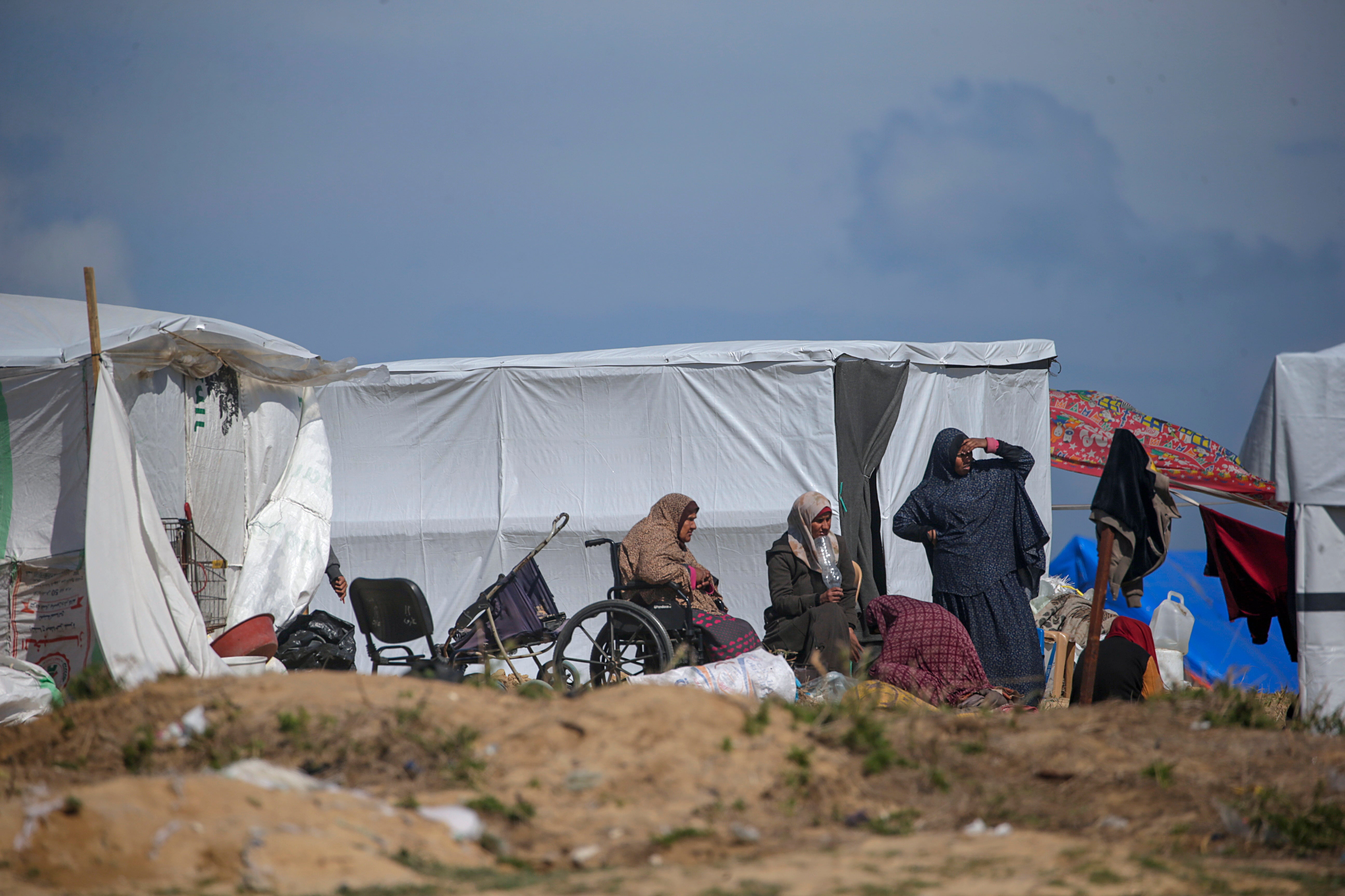 A Palestinian family displaced from Rafah sits outside their shelter in Deir Al Balah, southern Gaza Strip, 14 February 2024