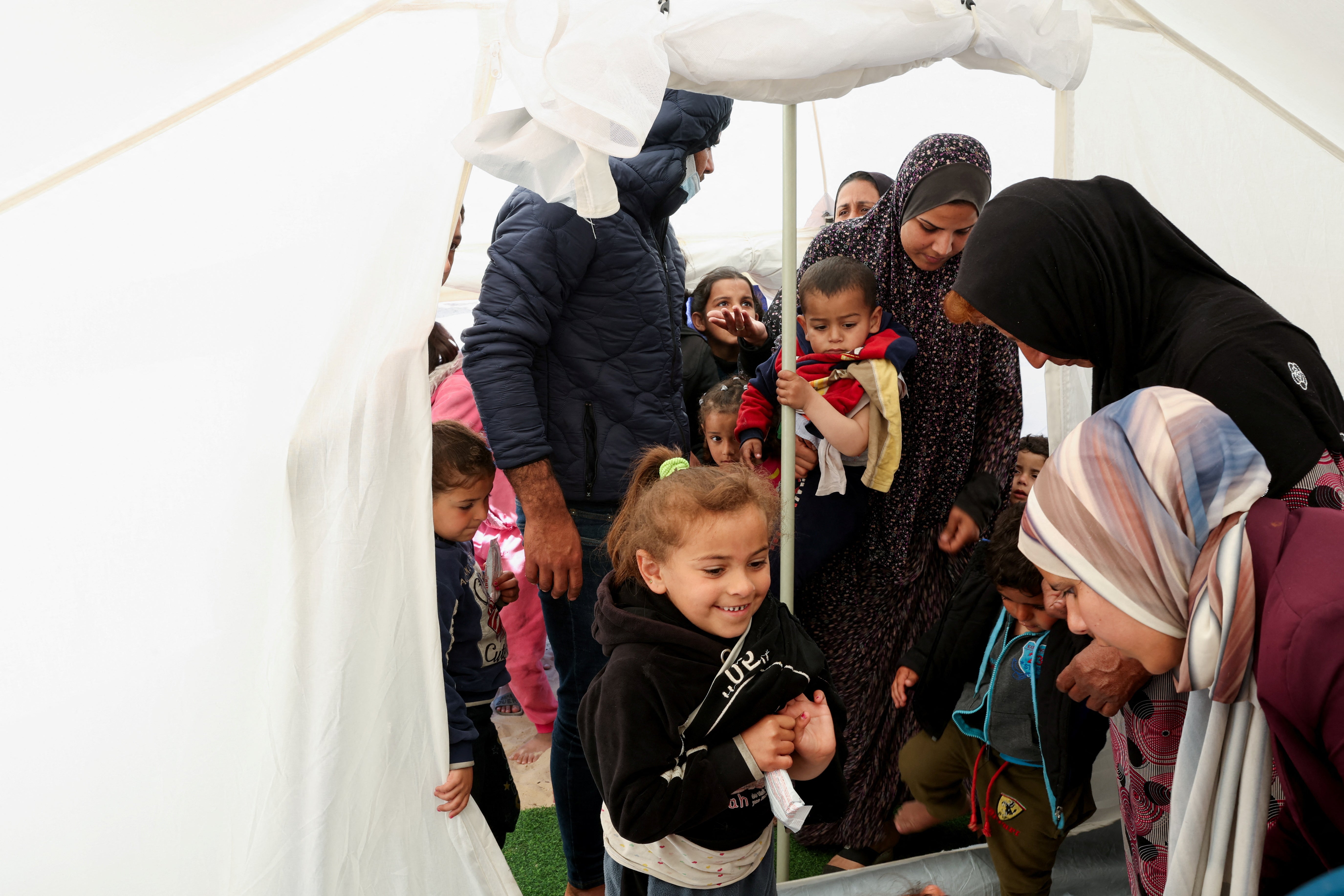 Palestinian children wait to be checked for malnutrition at a medical tent set up by MedGlobal in cooperation with Unicef, amid the ongoing conflict between Israel and the Palestinian Islamist group Hamas, in Rafah, in the southern Gaza Strip, 14 February 2024