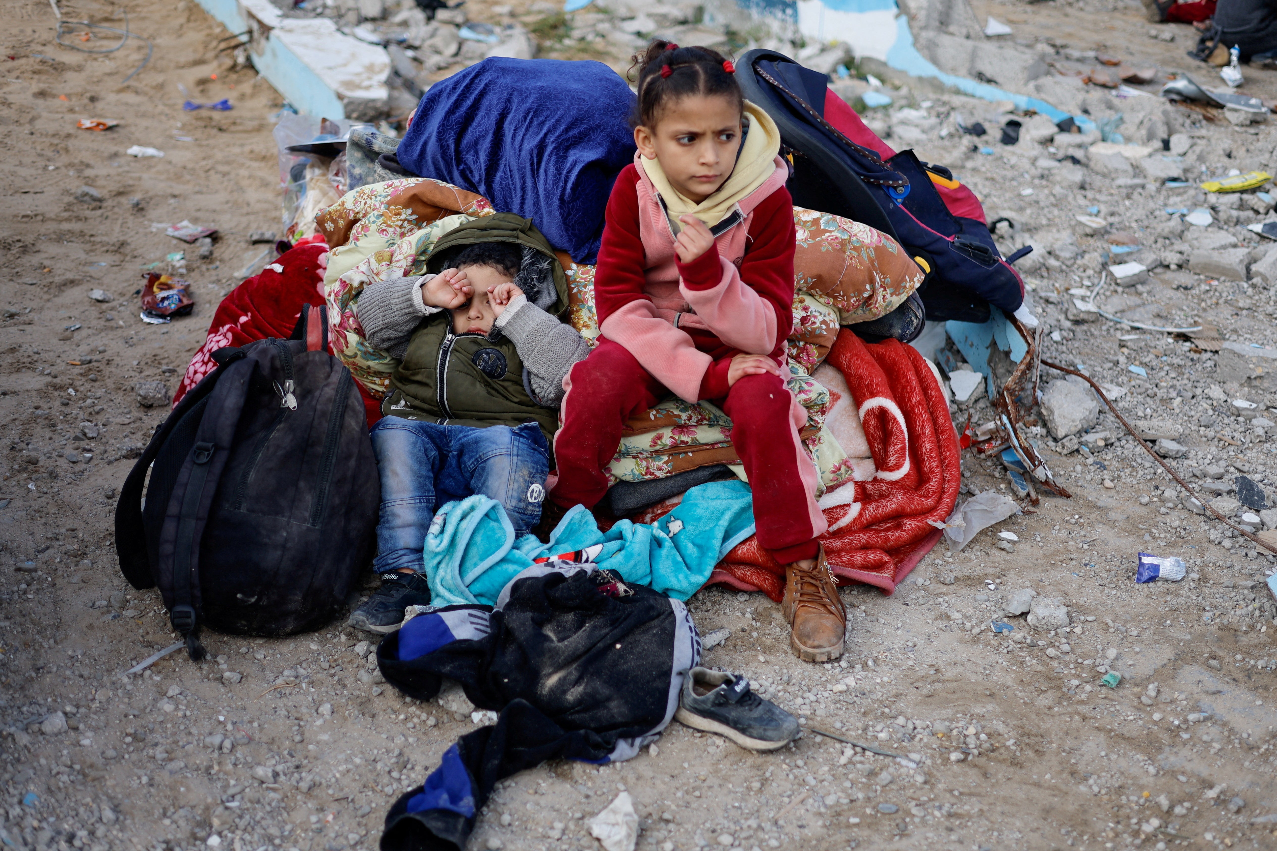 Children rest outside as Palestinian arrive in Rafah after they were evacuated from Nasser Hospital in Khan Younis