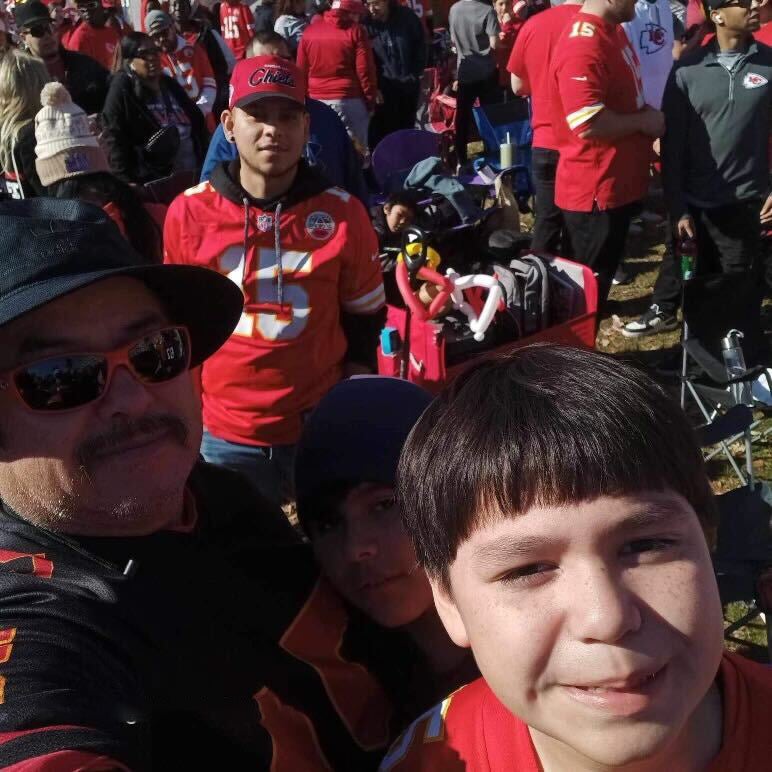 Samuel and his family pose at the parade before shooting rang out at Union Station, where the ten-year-old had been thrilled to see players in person speaking at the mics