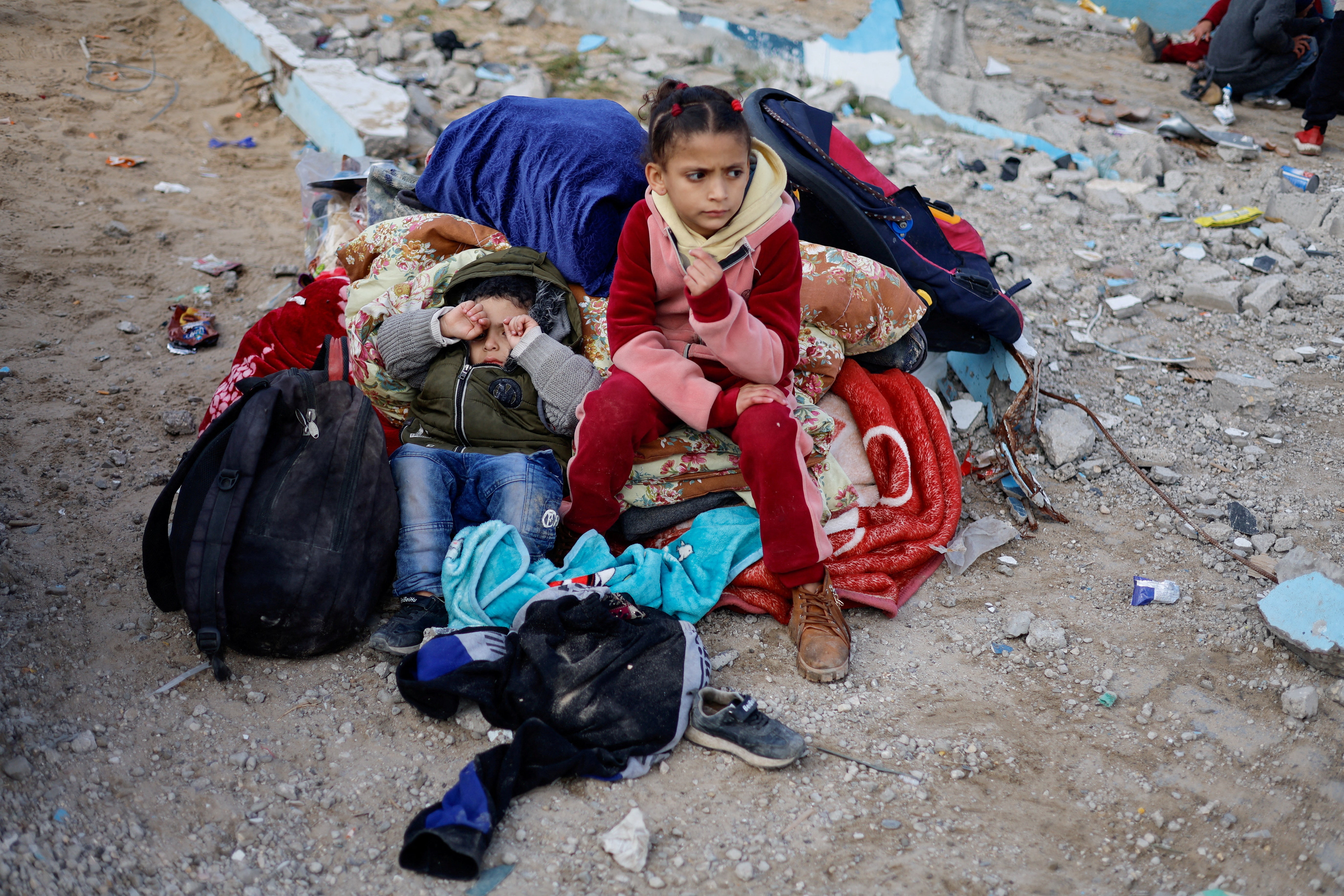 Children rest outside, as Palestinian arrive in Rafah after they were evacuated from Nasser hospital in Khan Younis