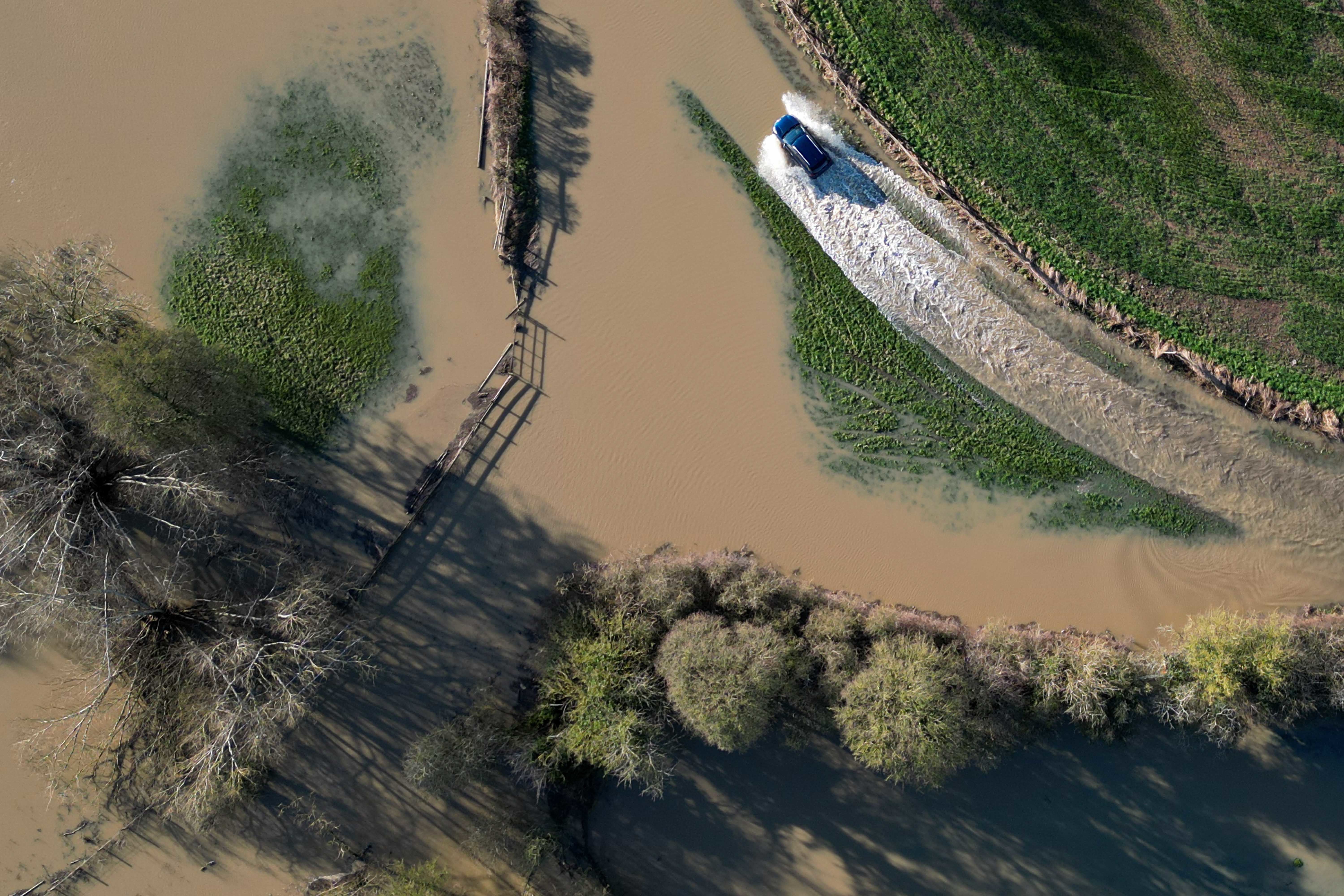 A vehicle passes through flood water in Walton, near to Stratford-upon-Avon, in Warwickshire on Friday, with more rain to come this weekend