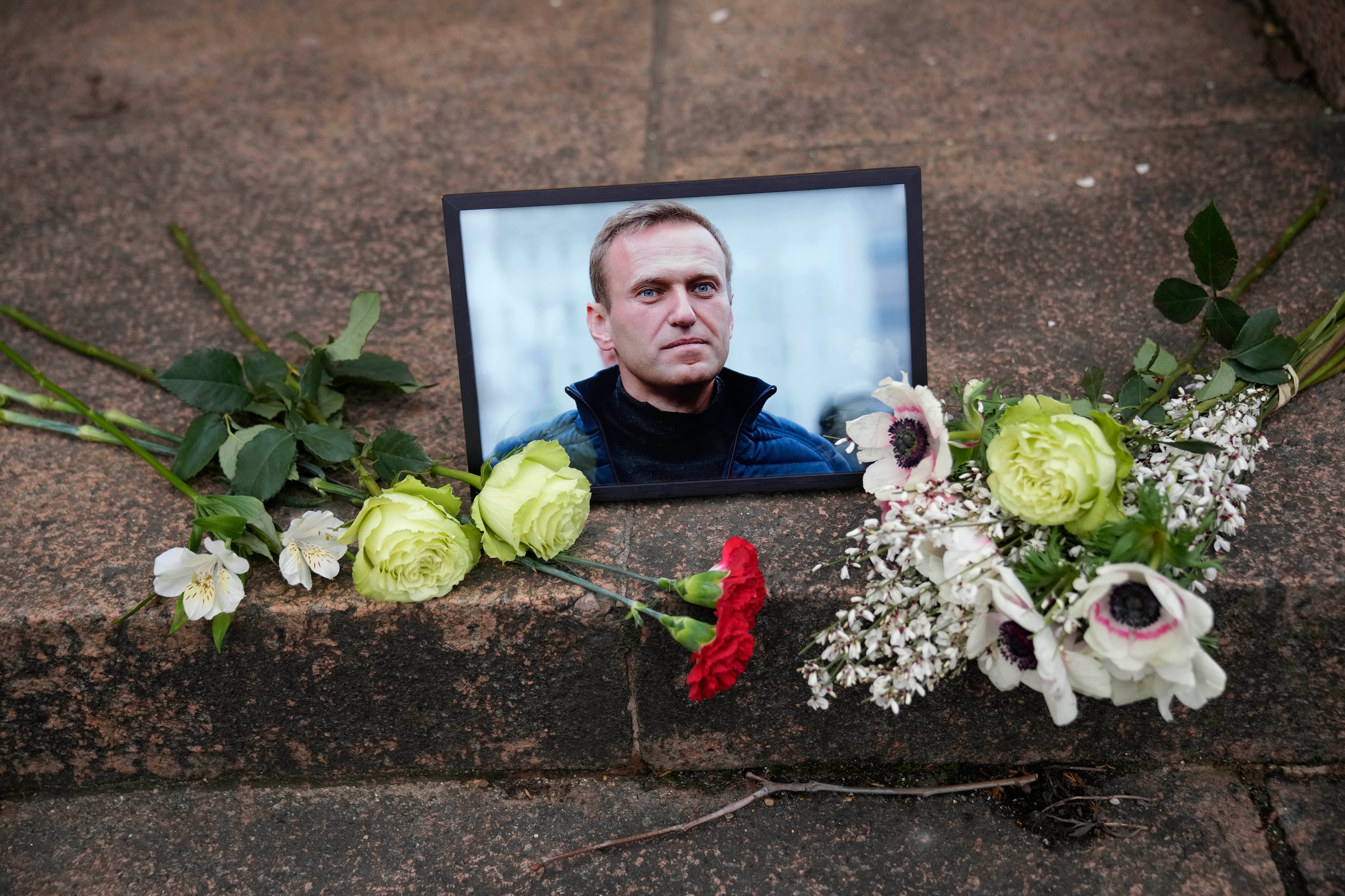 A portrait of jailed Russian opposition leader Alexei Navalny and flowers are placed as people demonstrate near to Russian embassy to France