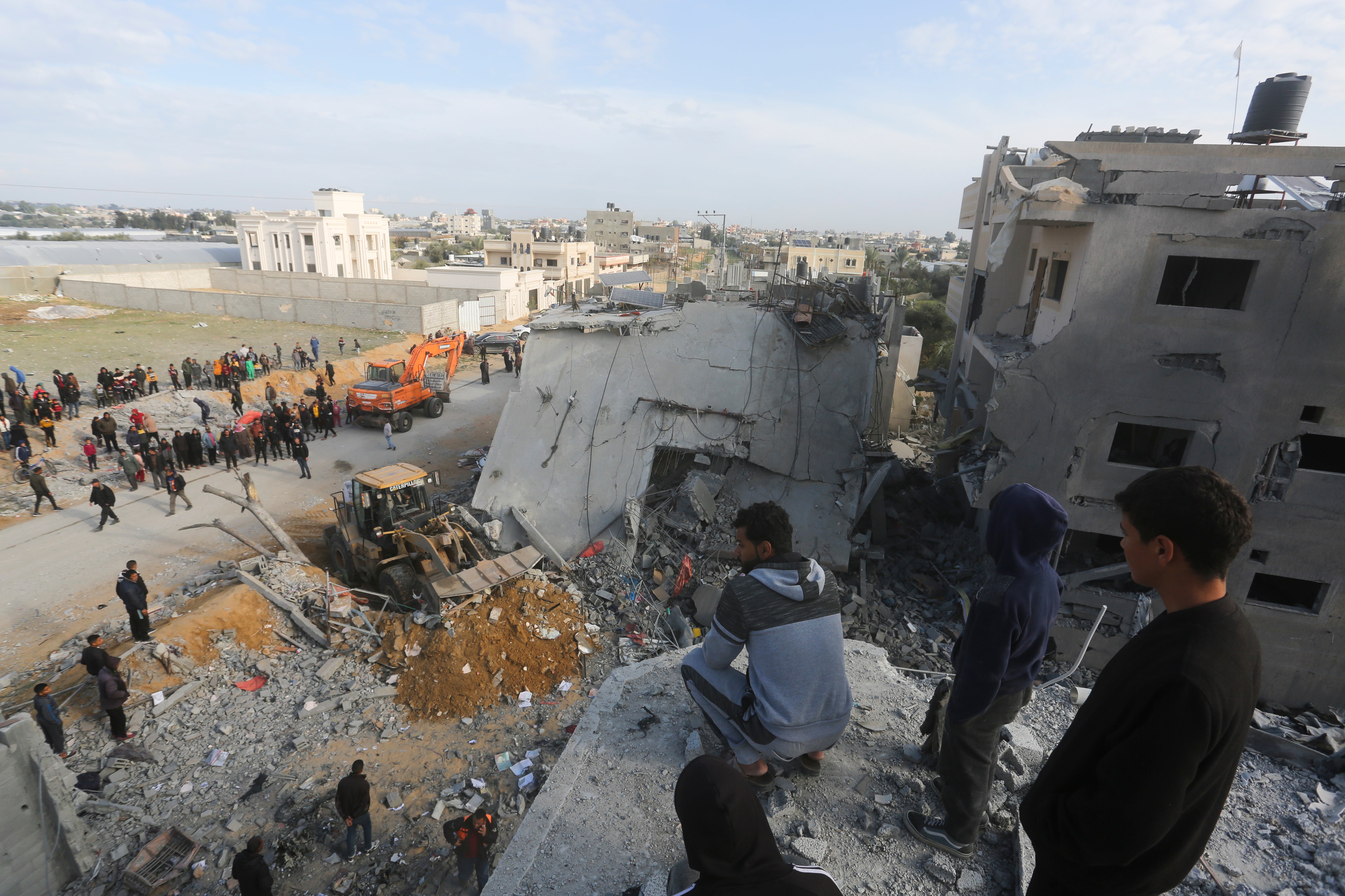 Palestinians view the destruction after an Israeli strike on a residential building in Rafah on Friday