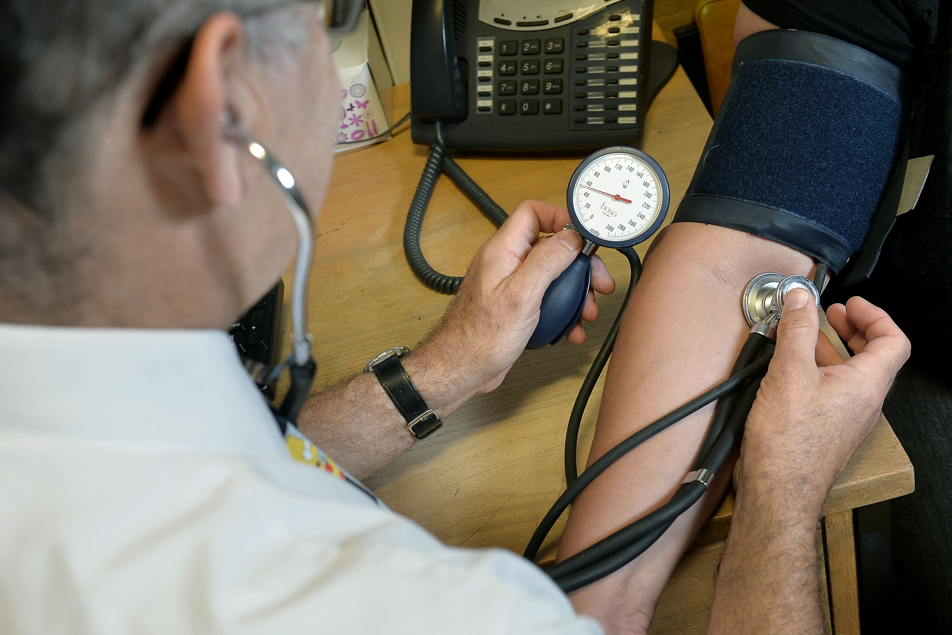 A GP checking a patient’s blood pressure (PA)