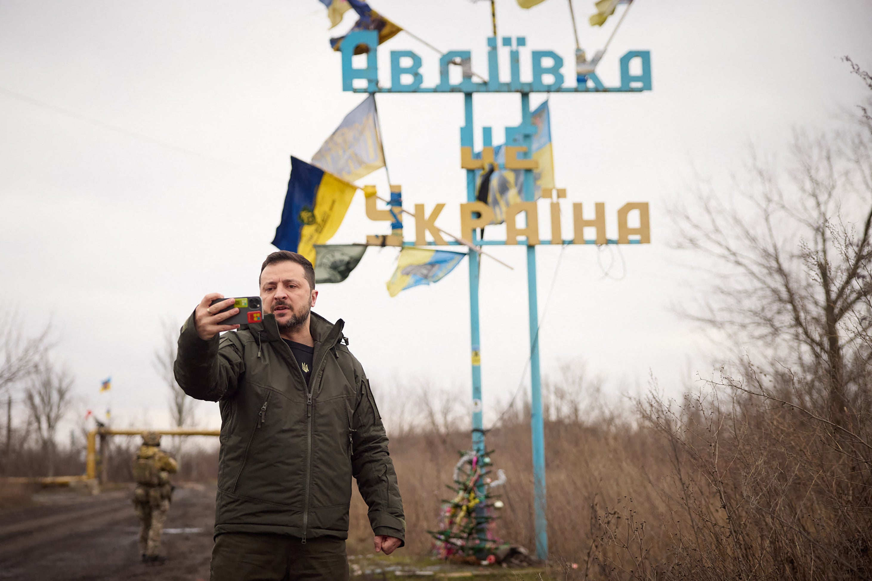 Ukrainian President Volodymyr Zelensky recording a video address in front of a sign reading ‘Avdiivka is Ukraine'