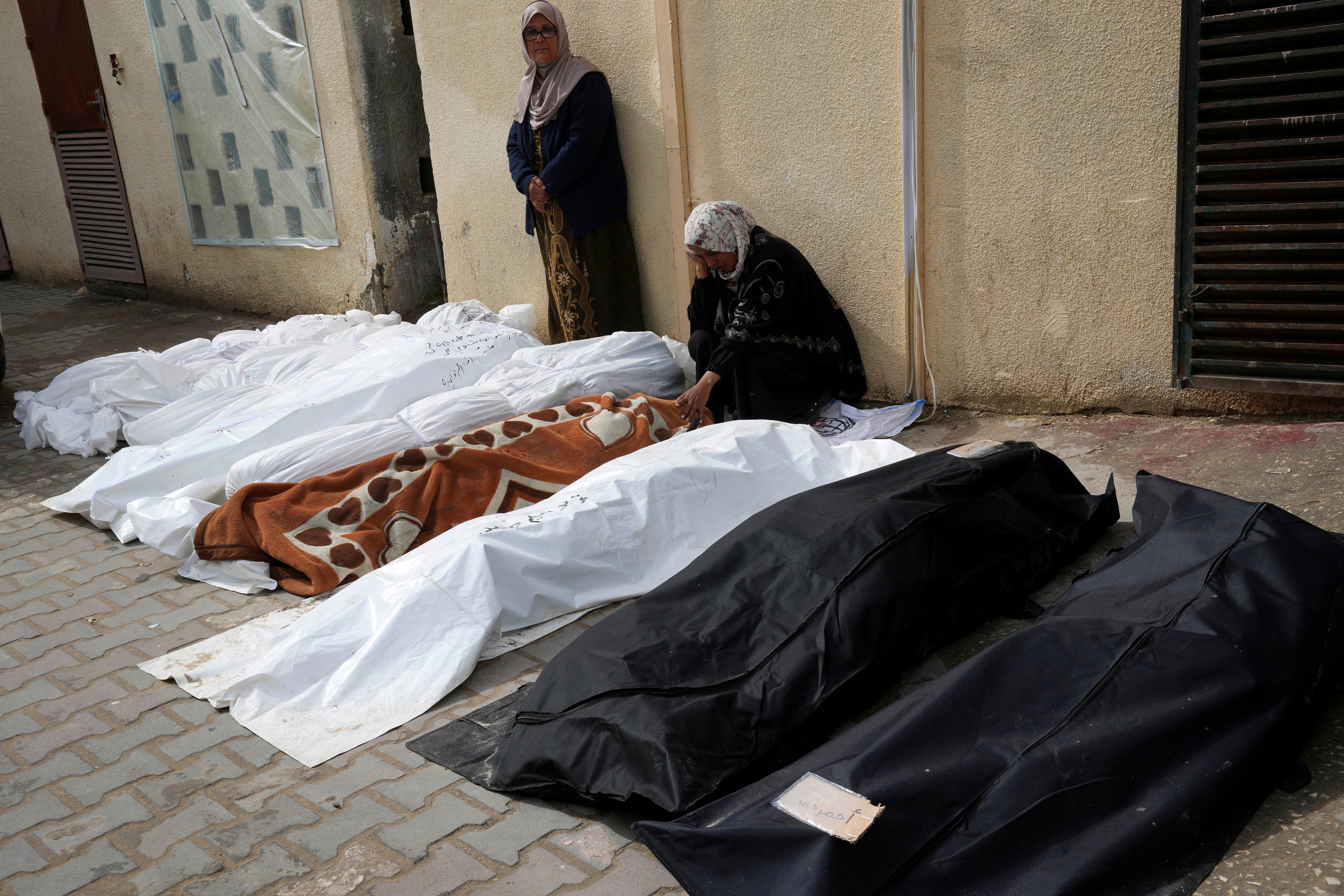 Palestinians mourn over their relatives killed in the Israeli bombardments of the Gaza Strip at Al Aqsa Hospital in Deir al Balah