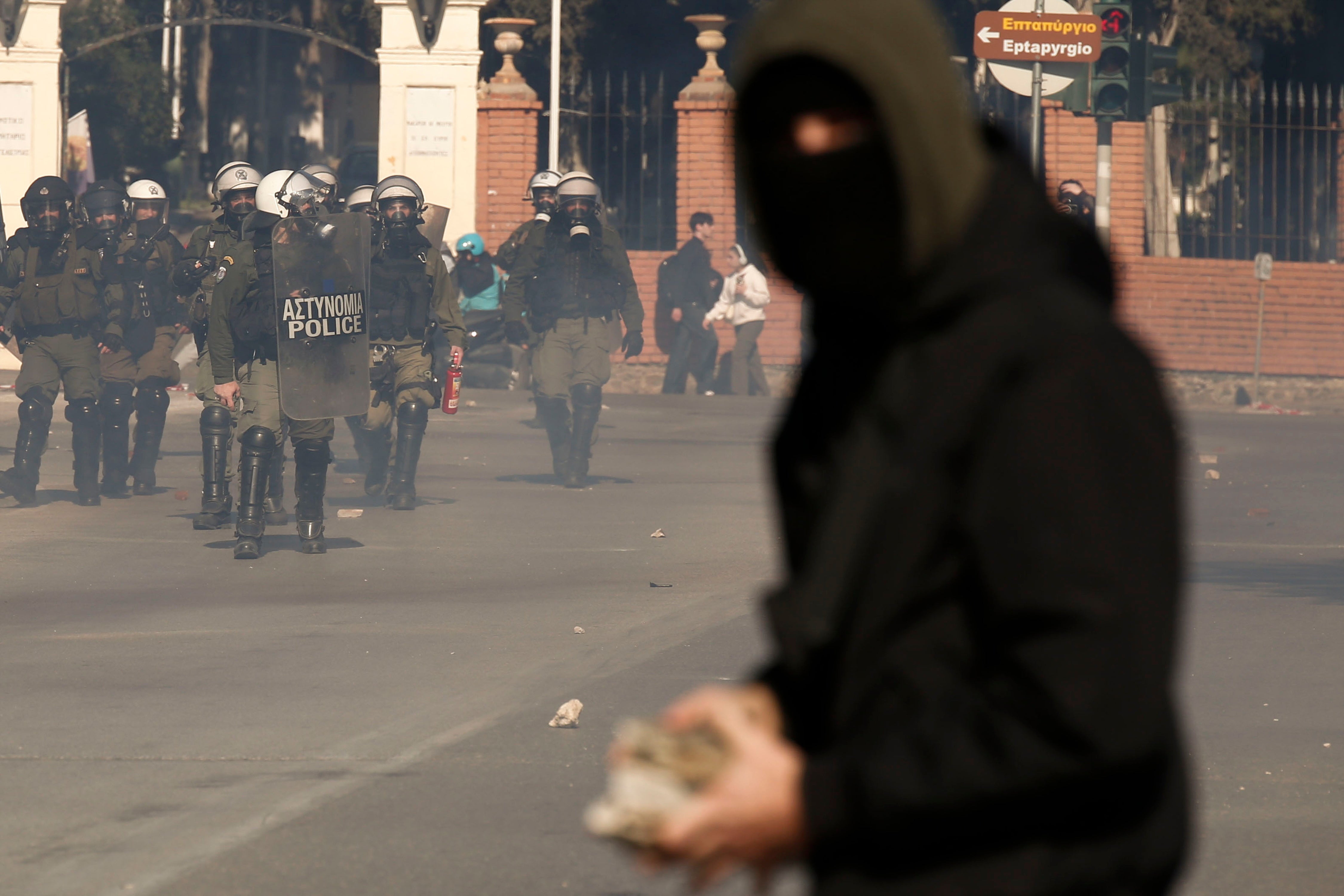 Riot policemen stand guard during clashes after the end of a rally against the planned new law, allowing establishment of private universities in the country, in Thessaloniki, Greece, 15 February 2024