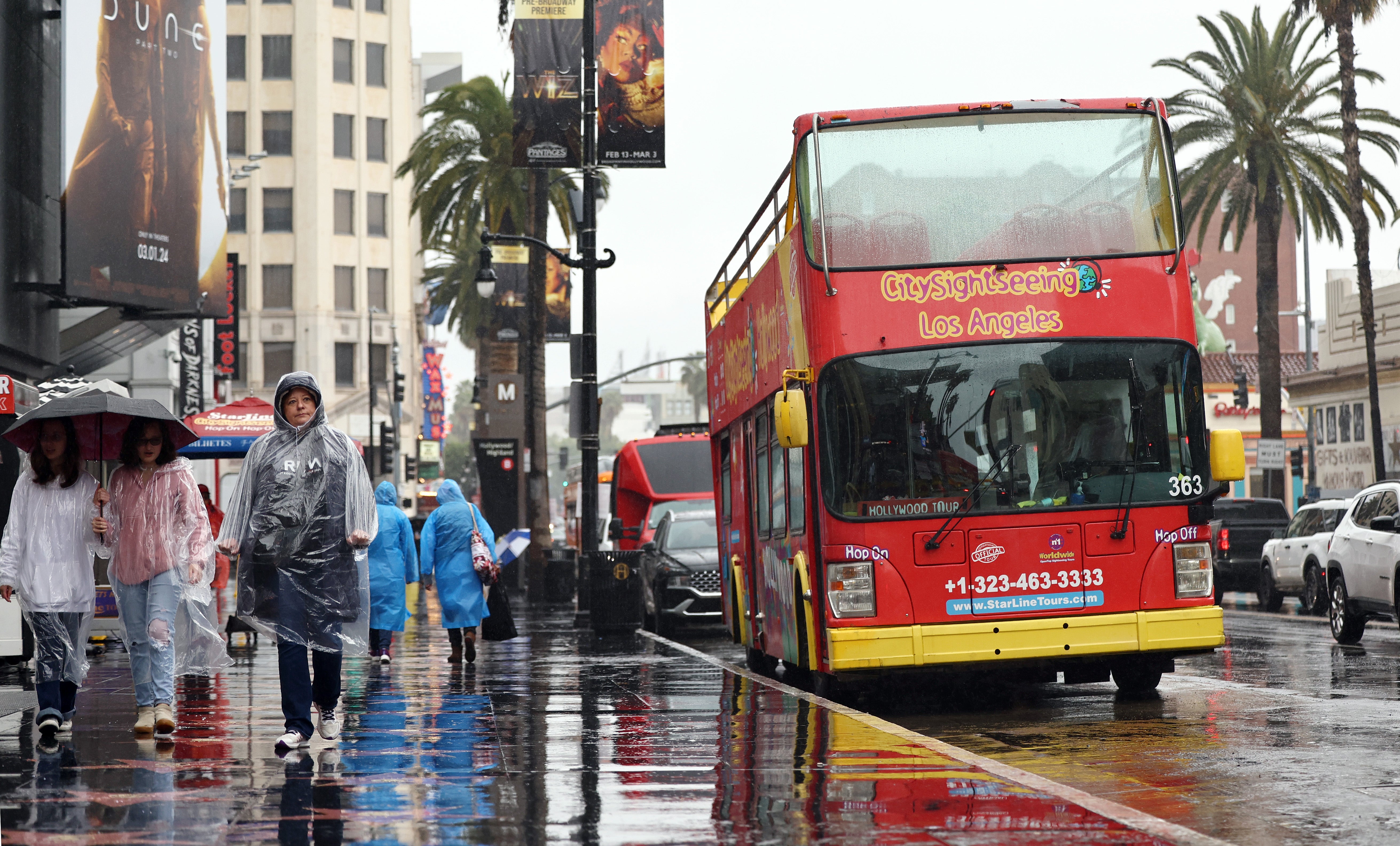 People walk on Hollywood Boulevard during a heavy downpour on 19 February 2024