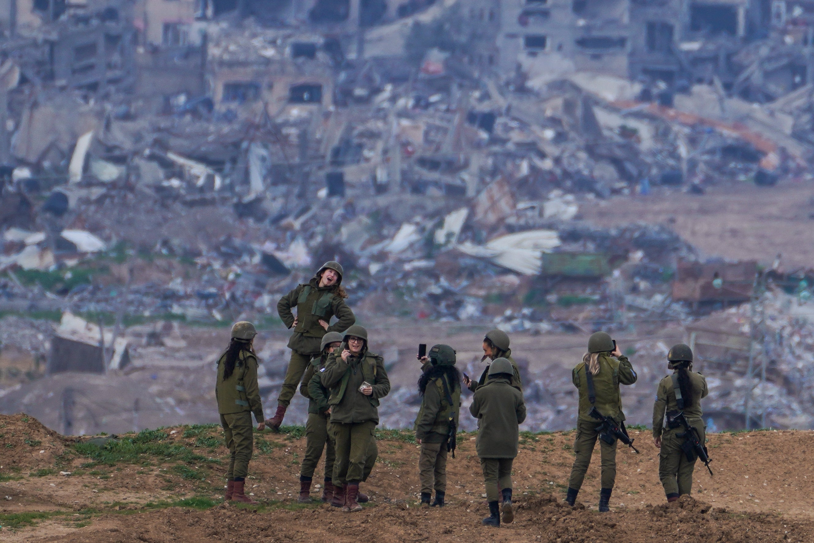 An Israeli female soldier pose for a photo taken by another soldier on a position on the Gaza Strip border