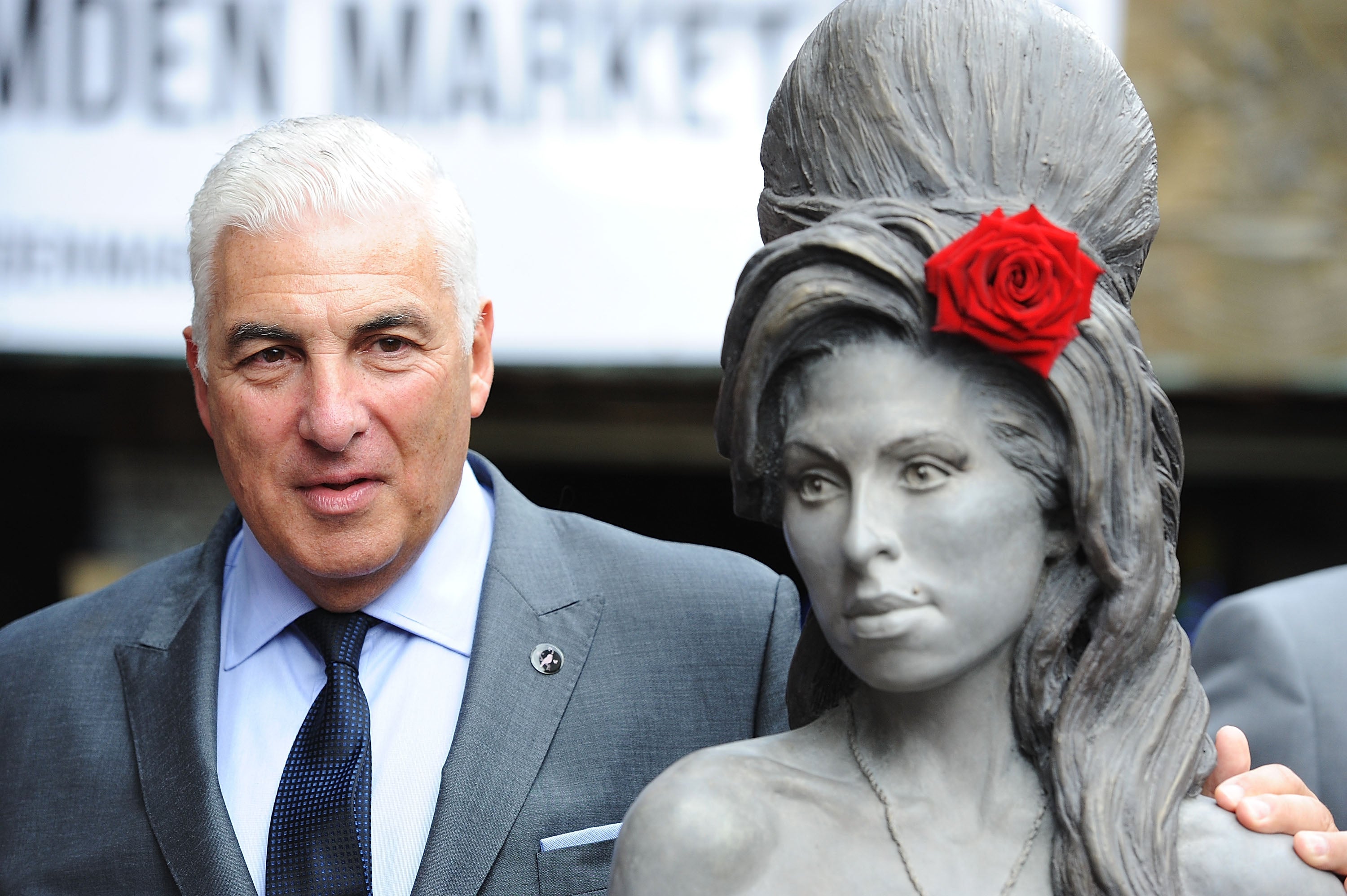 Mitch Winehouse poses as a statue of the late Amy Winehouse