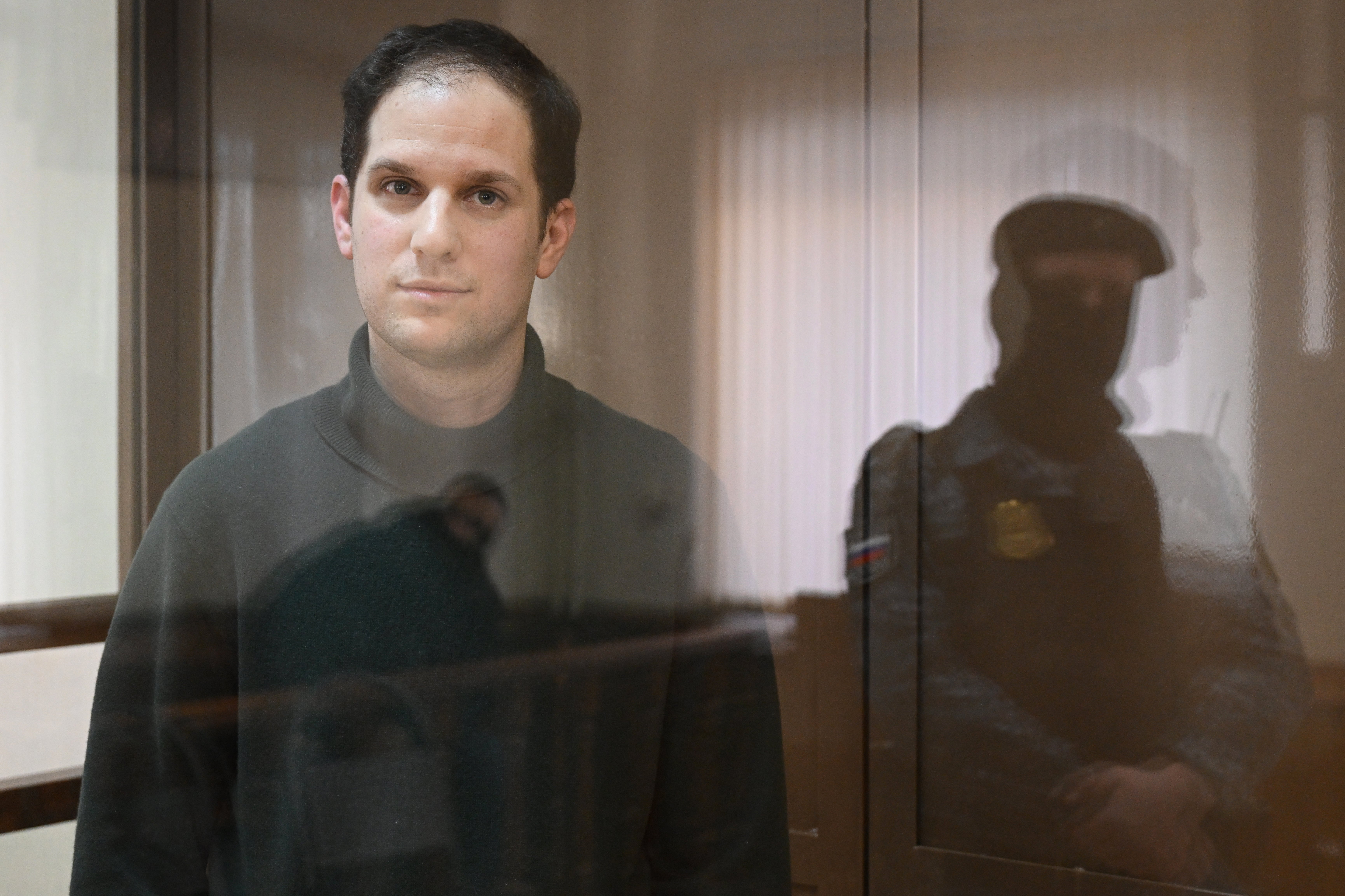 US journalist Evan Gershkovich, arrested on espionage charges, looks out from inside a defendants’ cage before a hearing to consider an appeal on his extended pre-trial detention, at the Moscow City Court in Moscow on 20 February, 2024