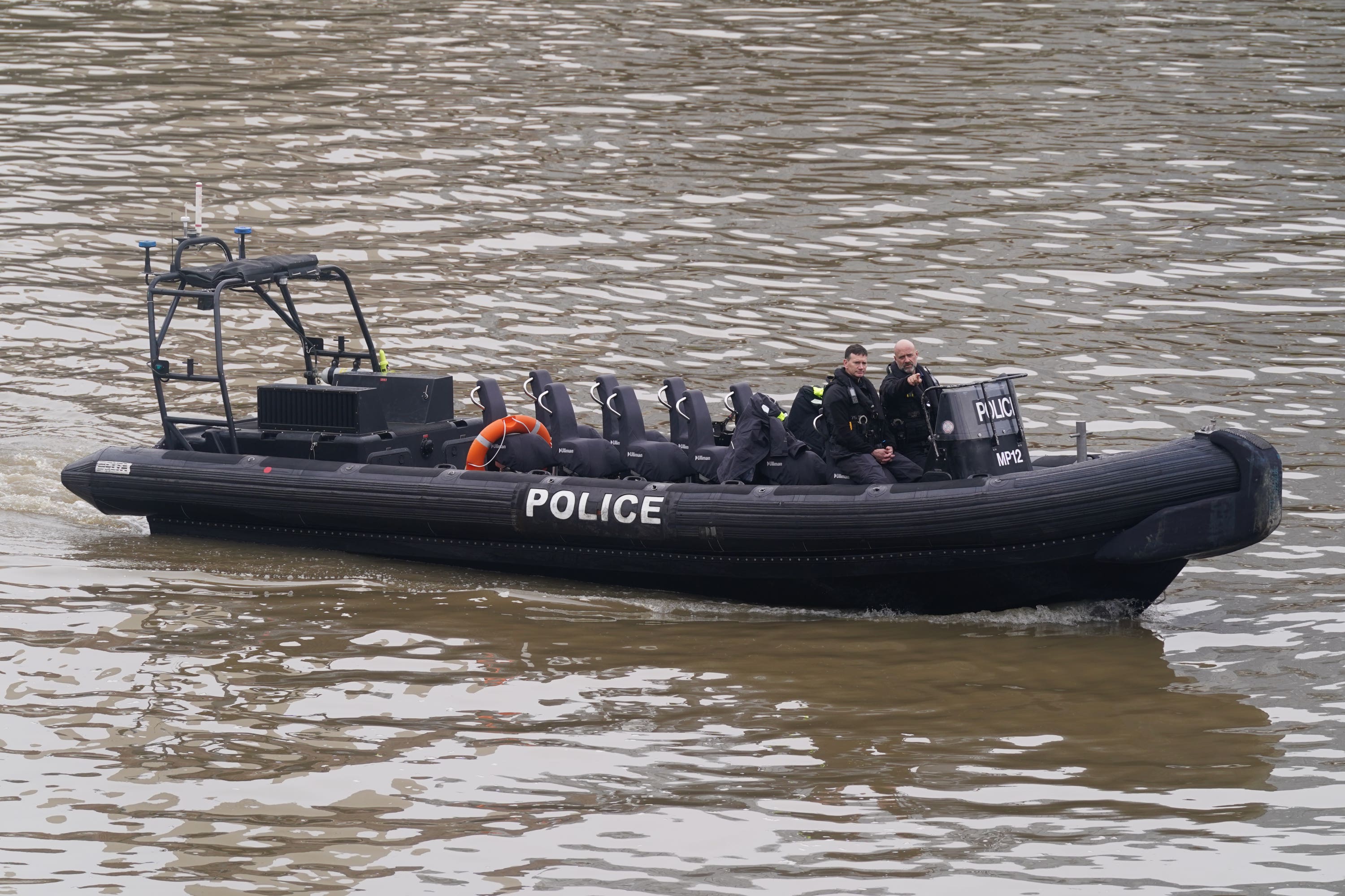 Members of the Metropolitan Police Marine Policing Unit pass near to Chelsea Bridge (Lucy North/PA)