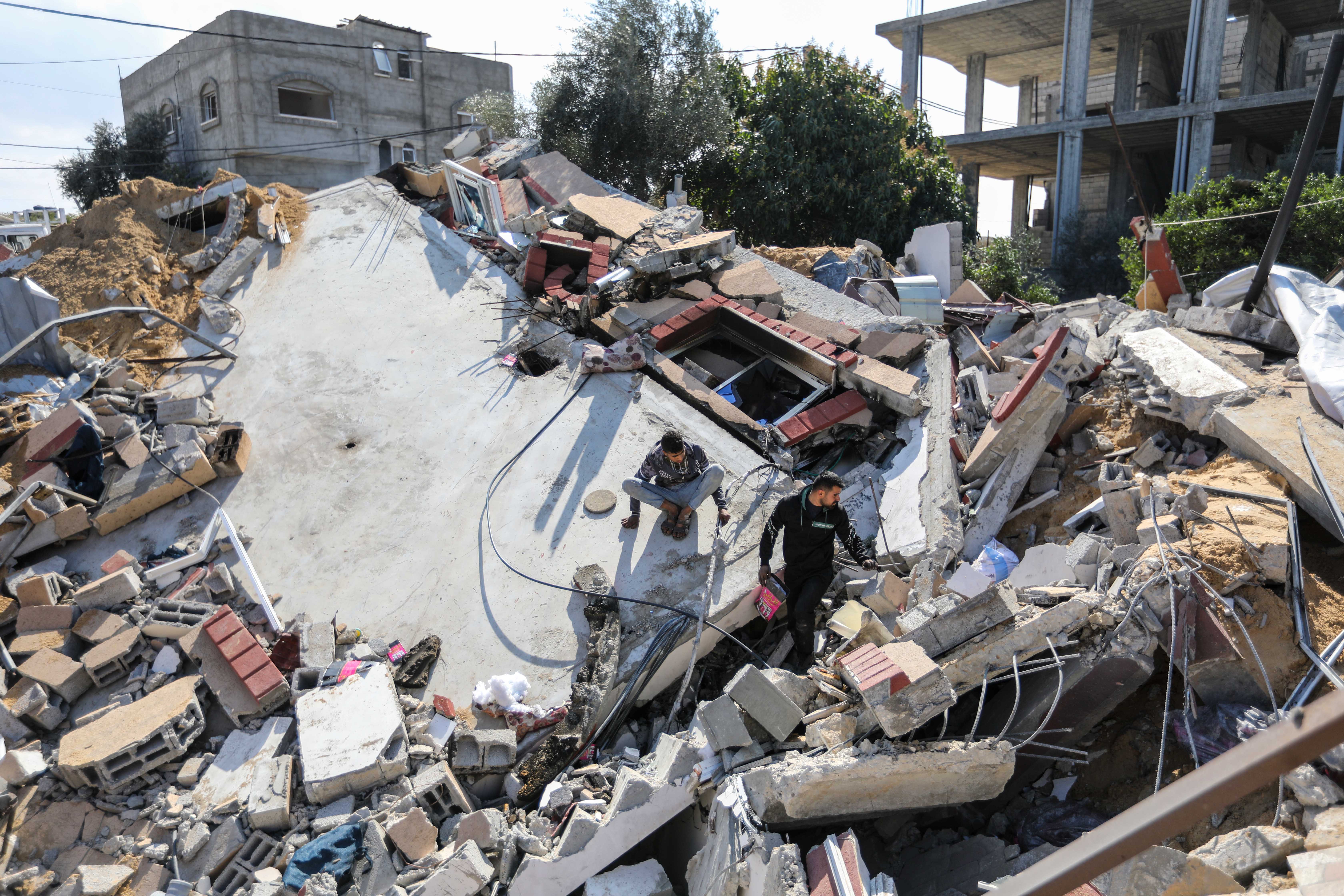 People inspect the damage to their homes following Israeli air strikes on Tuesday in Rafah, Gaza