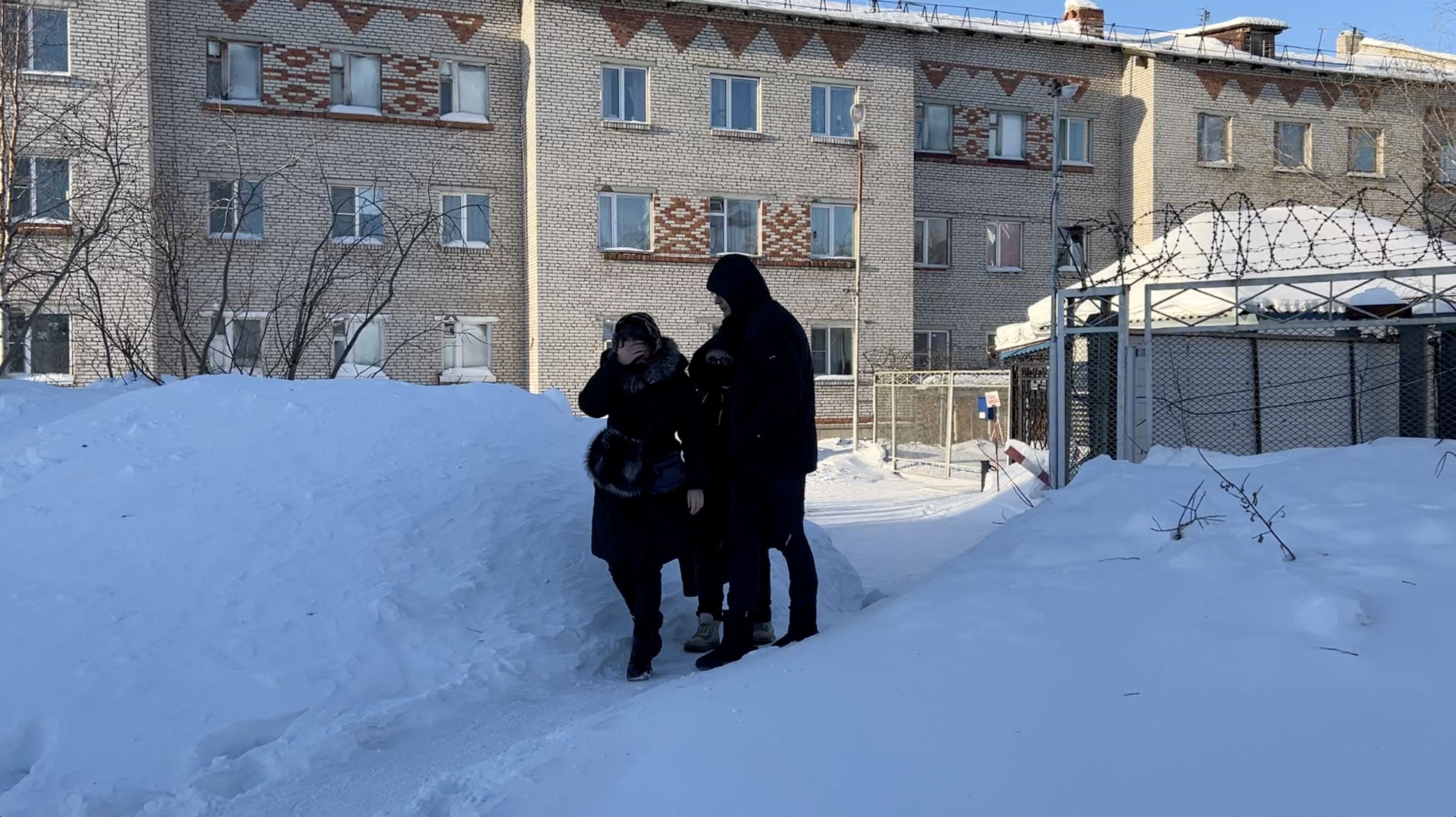 Lyudmila Navalnaya, the mother of Russian opposition leader Alexei Navalny, is accompanied into a car as she leaves the IK-3 penal colony, where her son served his jail term and where he died