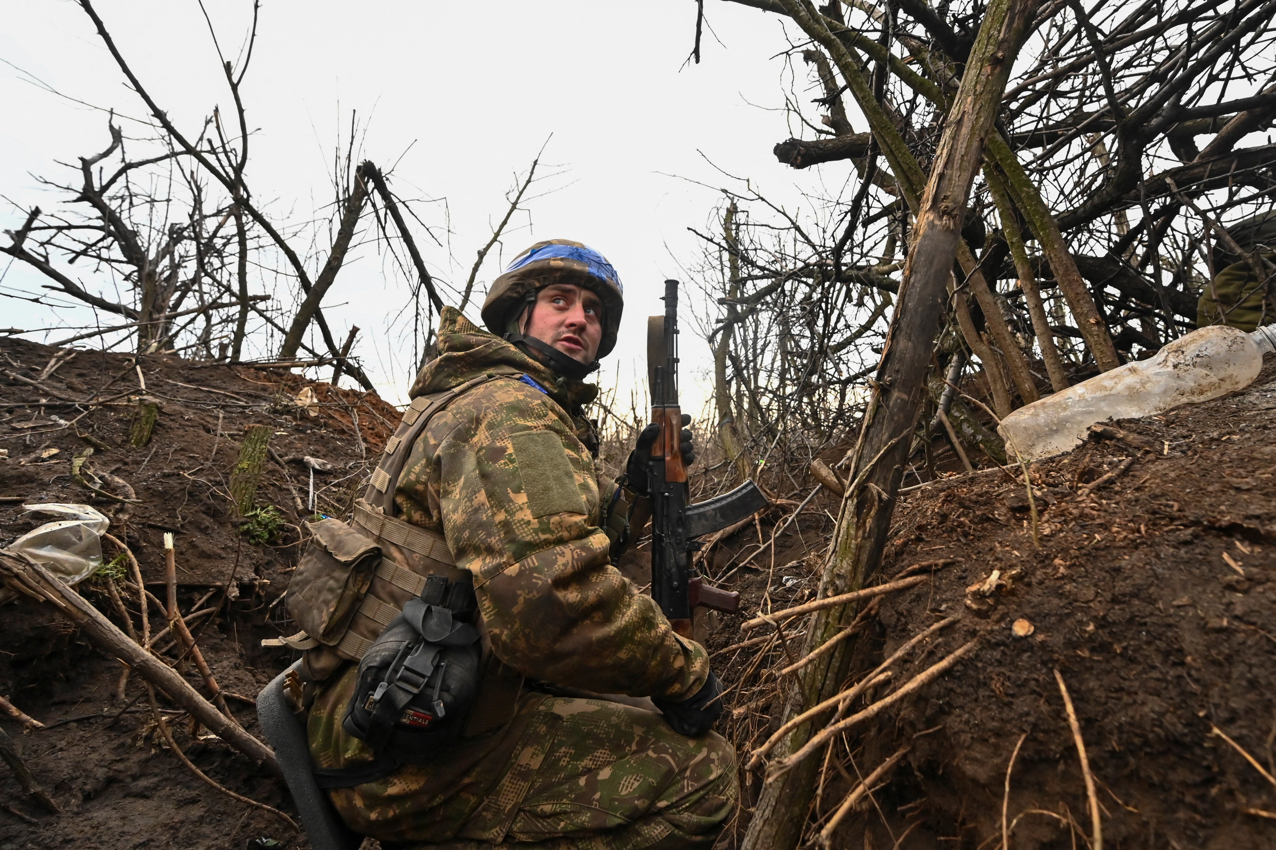 A serviceman of the 65th Mechanised Brigade looks on from a trench near the frontline village of Robotyne