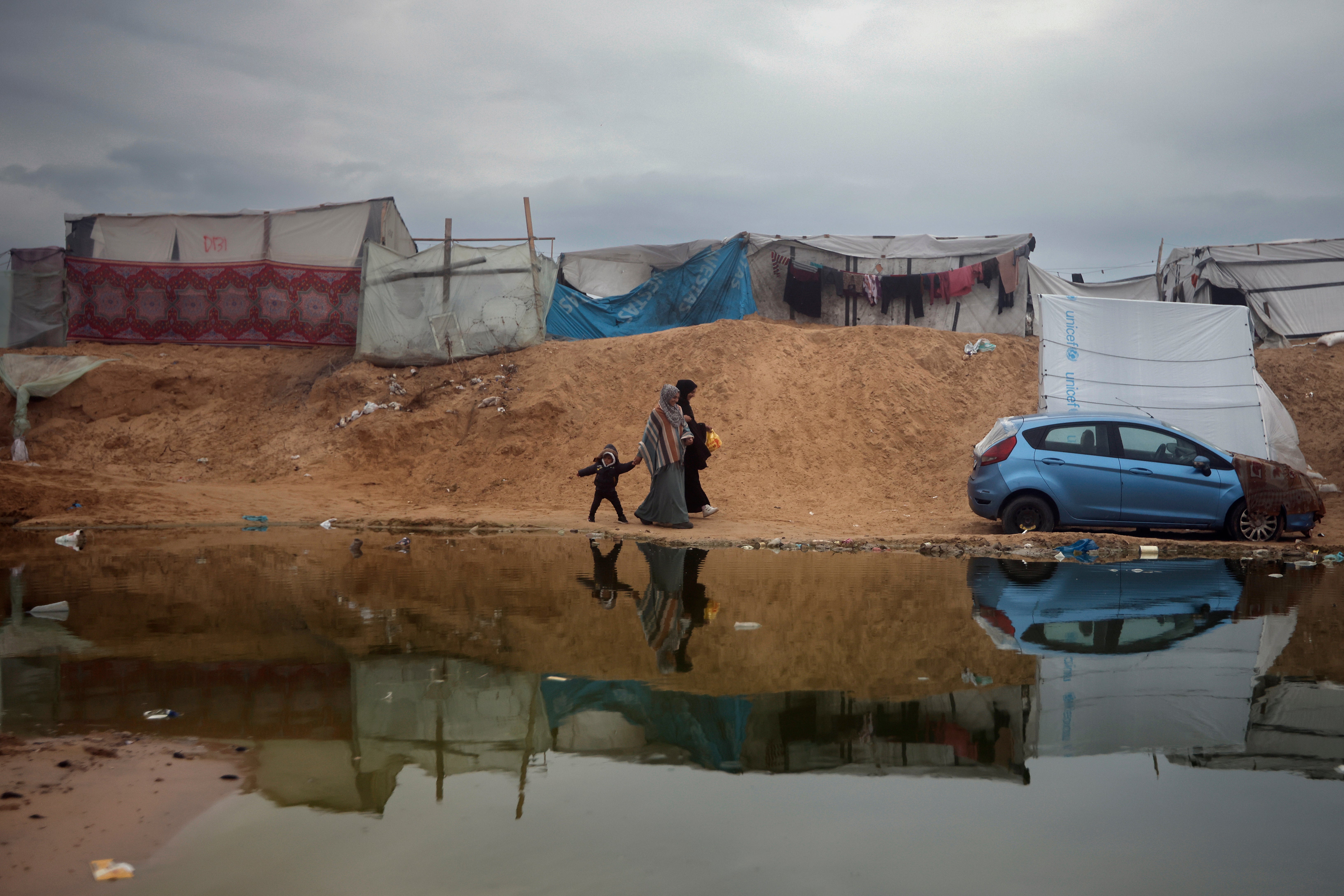 Two Palestinian women and a child walk in the Rafah refugee camp in southern Gaza