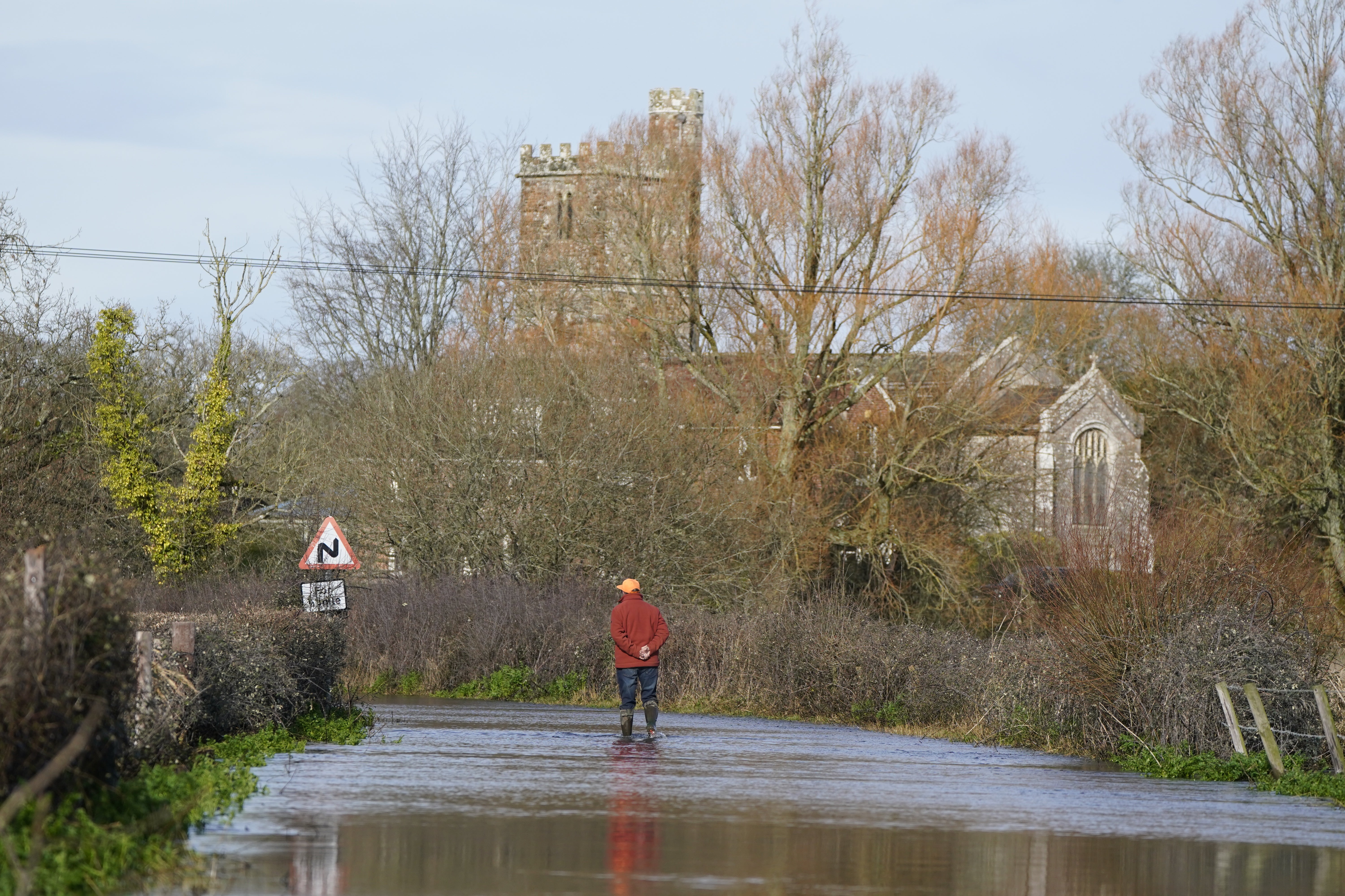 Aman looks at floodwater in Harbridge, Hampshire. Schools have been closed and transport disrupted after a burst of "some quite lively and active showers" across England and Wales. Heavy rain fell on already saturated ground, flooding roads and railway lines on Thursday. Picture date: Friday February 23, 2024