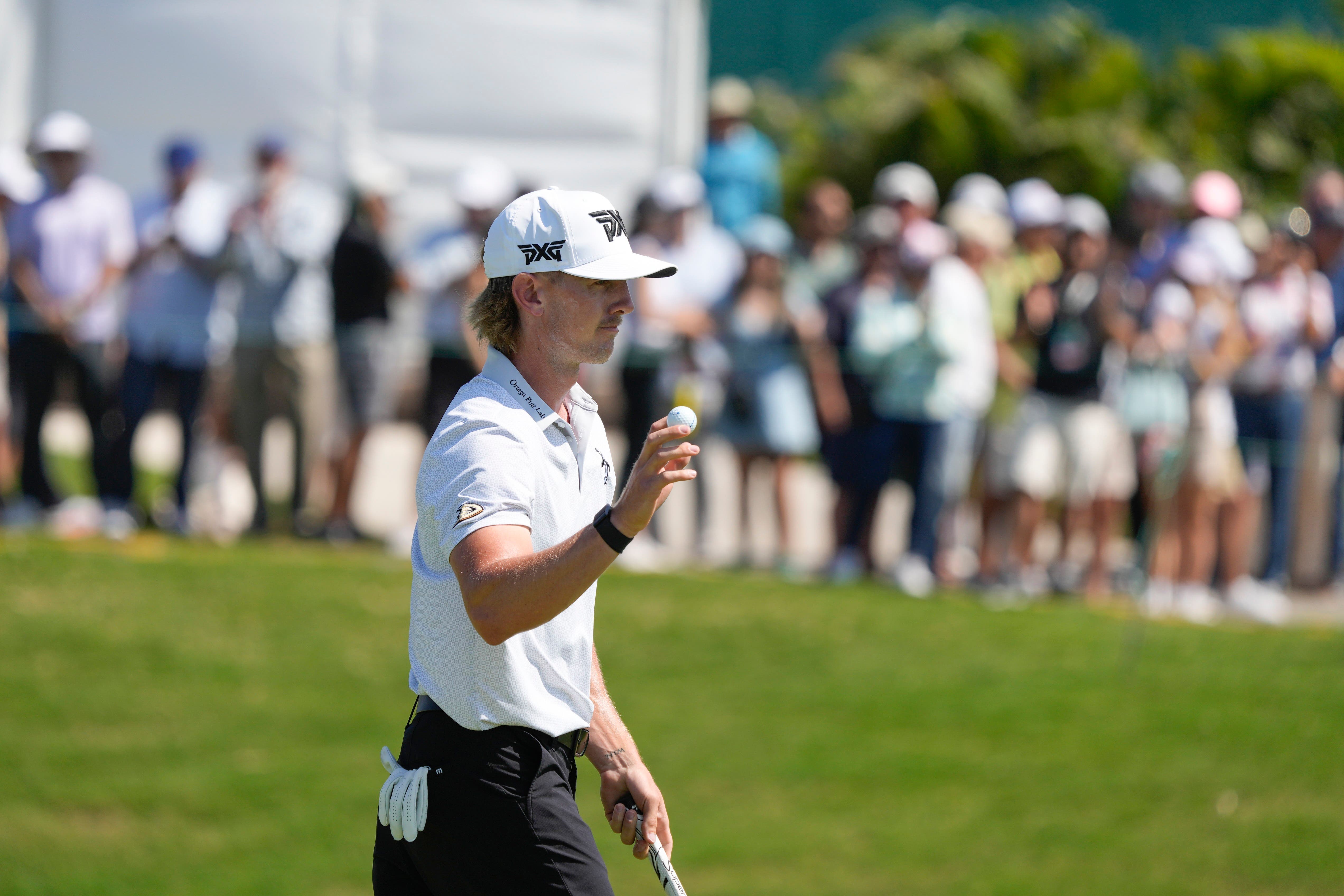 Jake Knapp, of the United States, holds up his ball after a birdie on the ninth (Fernando Llano/AP)