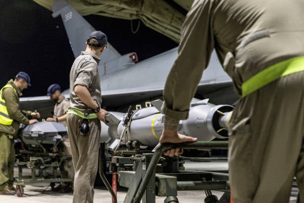 A handout picture released by the British Ministry of Defence (MOD) on 24 February 2024 shows a Royal Air Force Typhoon FGR4 having Paveway IV weapons loaded by Weapon Technicians at RAF Akrotiri in Cyprus, in preparation for a strike on military targets in Yemen, on 22 February 2024