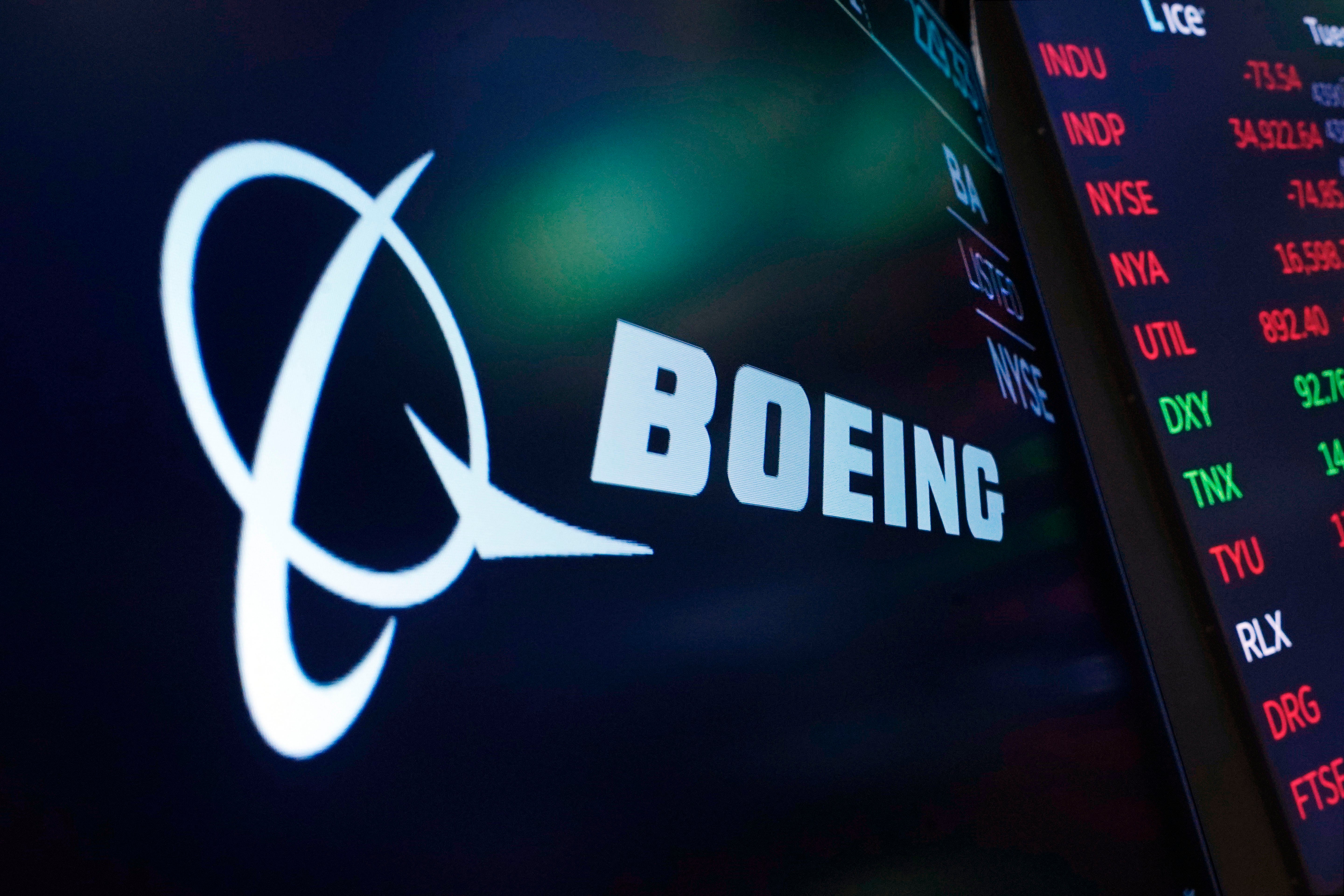 The logo for Boeing appears on a screen above a trading post on the floor of the New York Stock Exchange