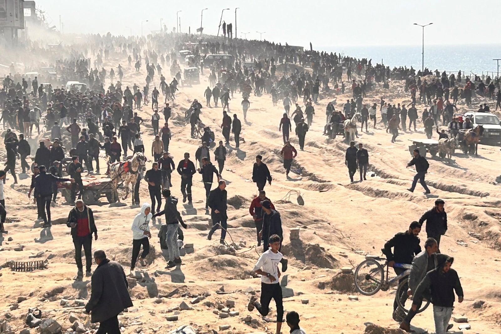 Palestinians wait for humanitarian aid on a beachfront in Gaza City on Sunday