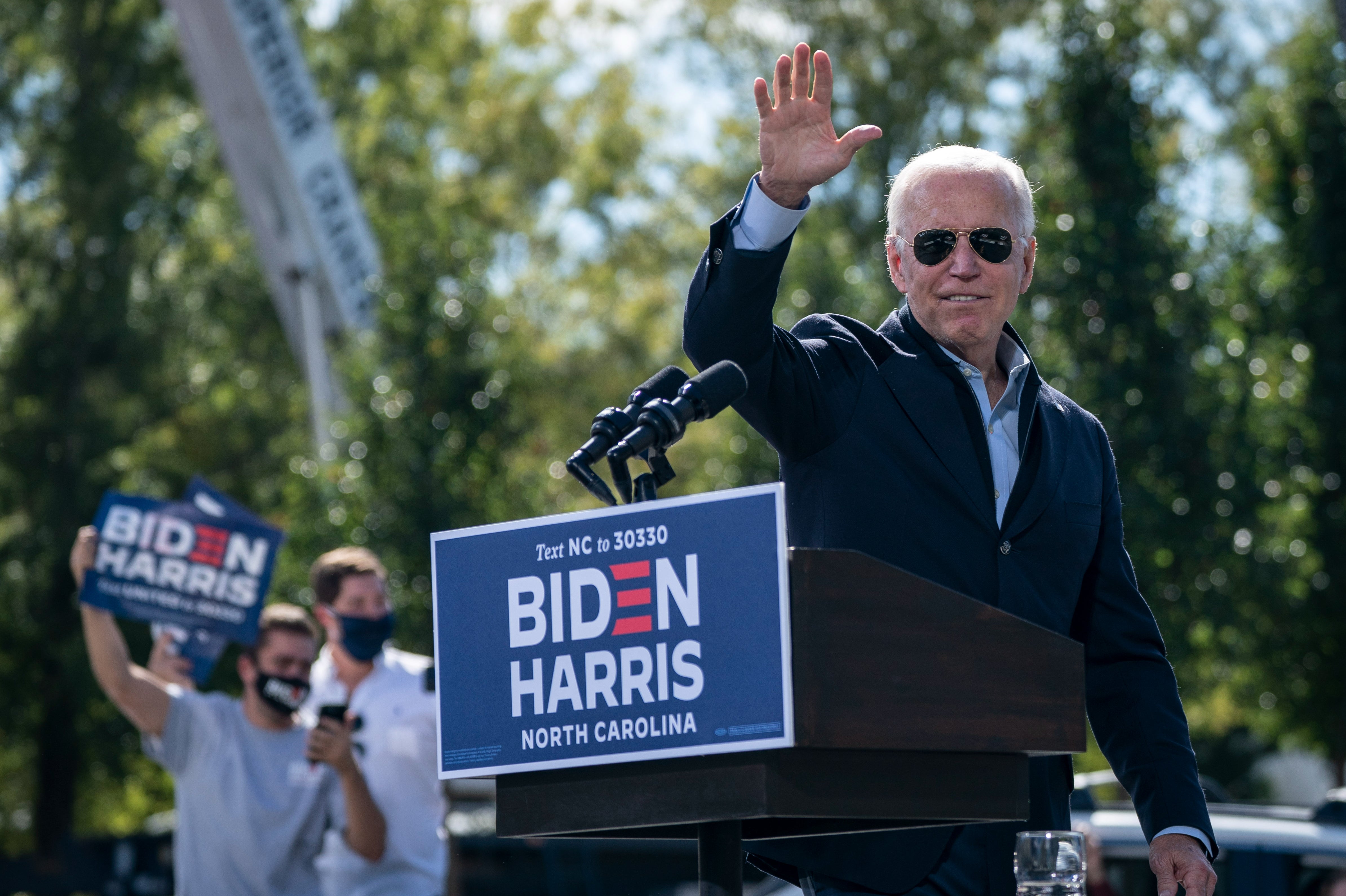 Democratic presidential nominee Joe Biden waves as he departs the stage during a drive-in campaign rally at Riverside High School on October 18, 2020 in Durham, North Carolina.