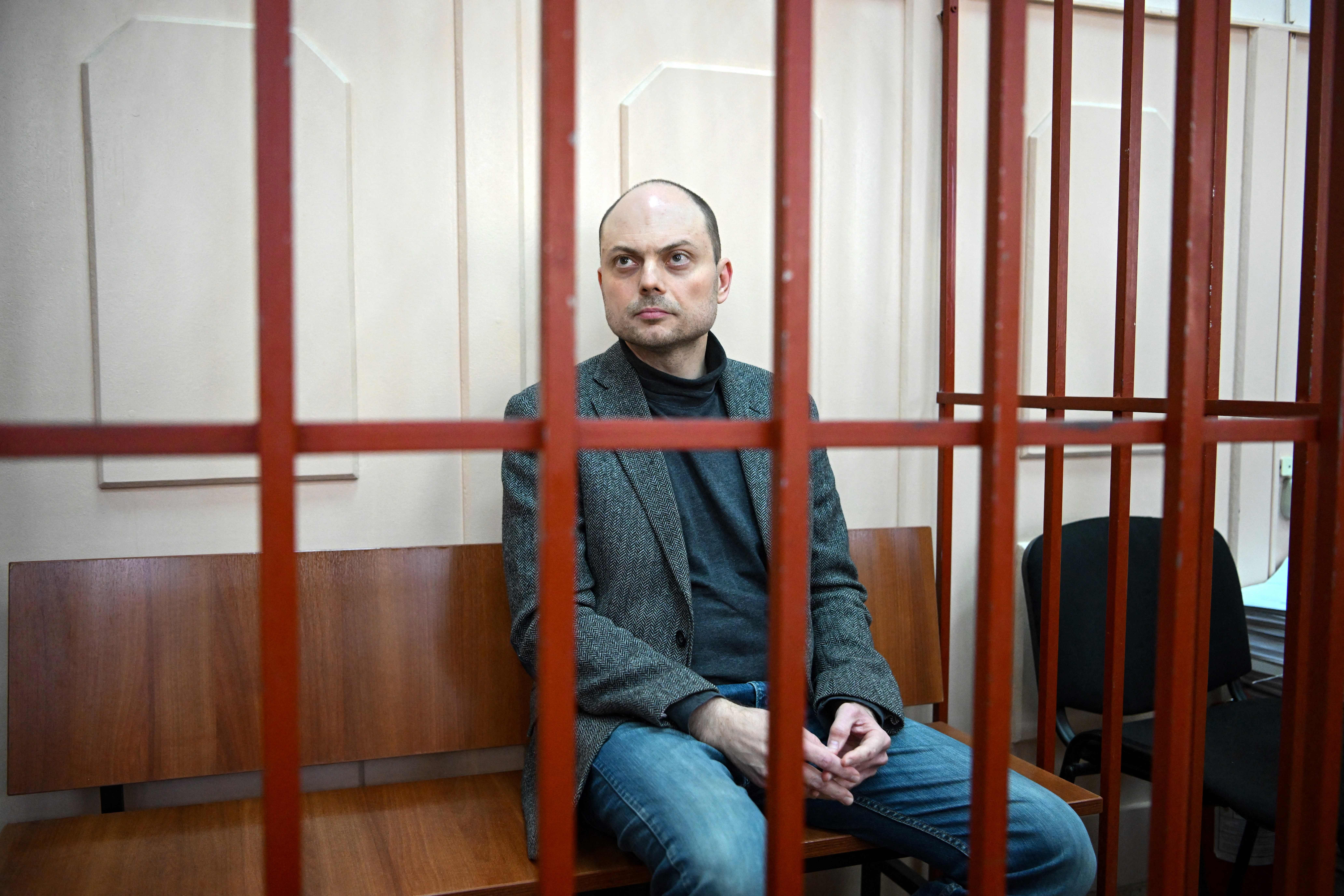 Russian opposition activist Vladimir Kara-Murza sits on a bench inside a defendants’ cage during a hearing at the Basmanny court in Moscow in 2022