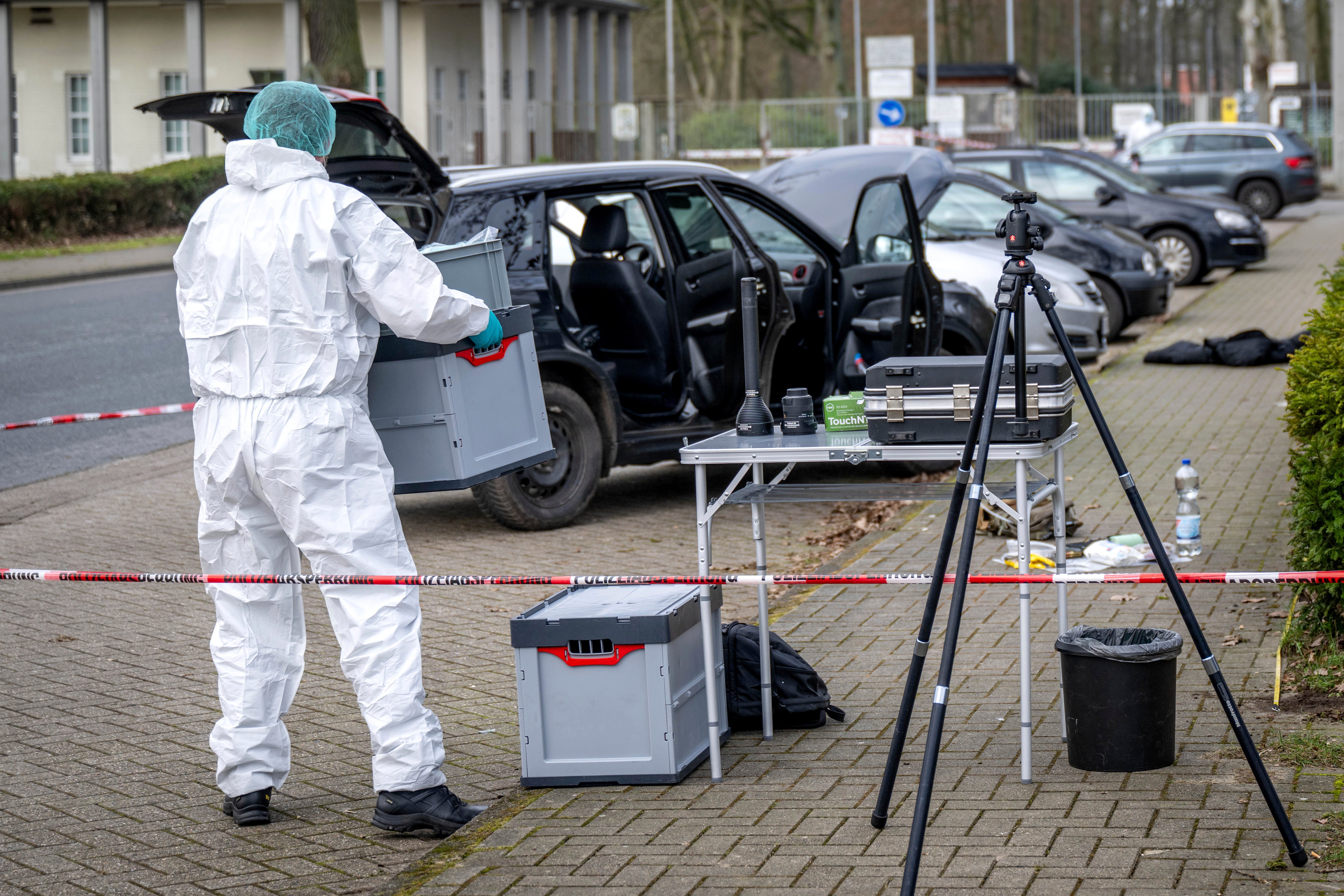 A forensics officer works near a car in front of the Von D’ring barracks in Rotenburg