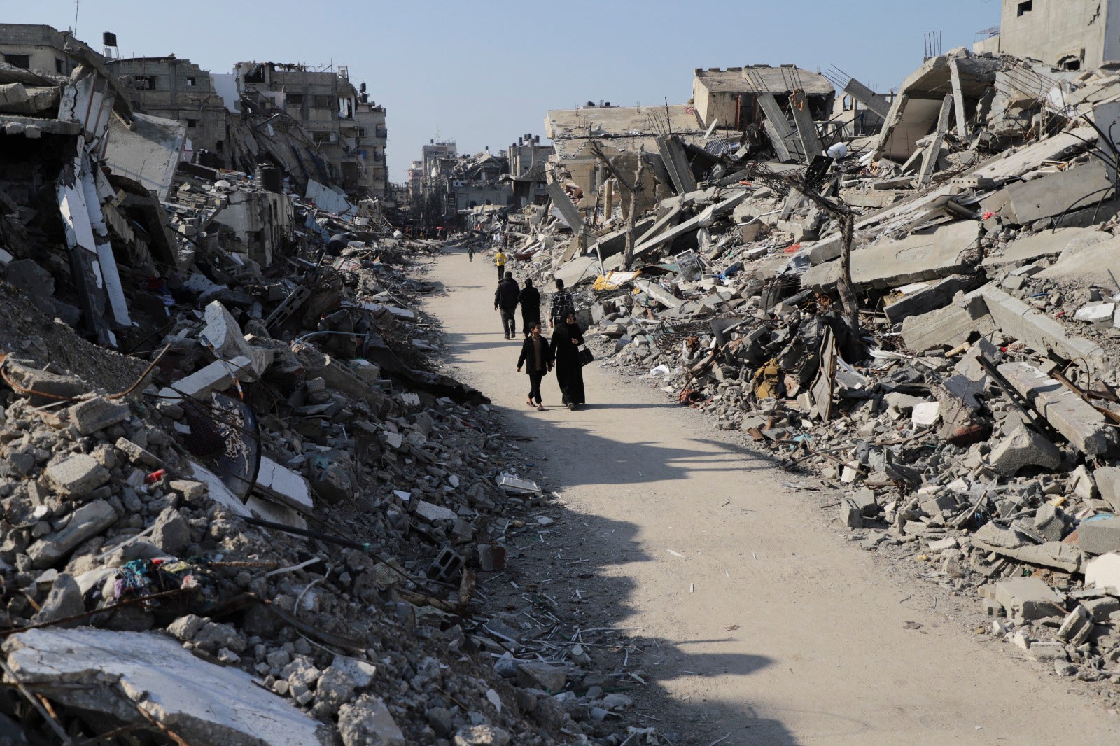 Palestinians walking through the rubble at Jabaliya refugee camp