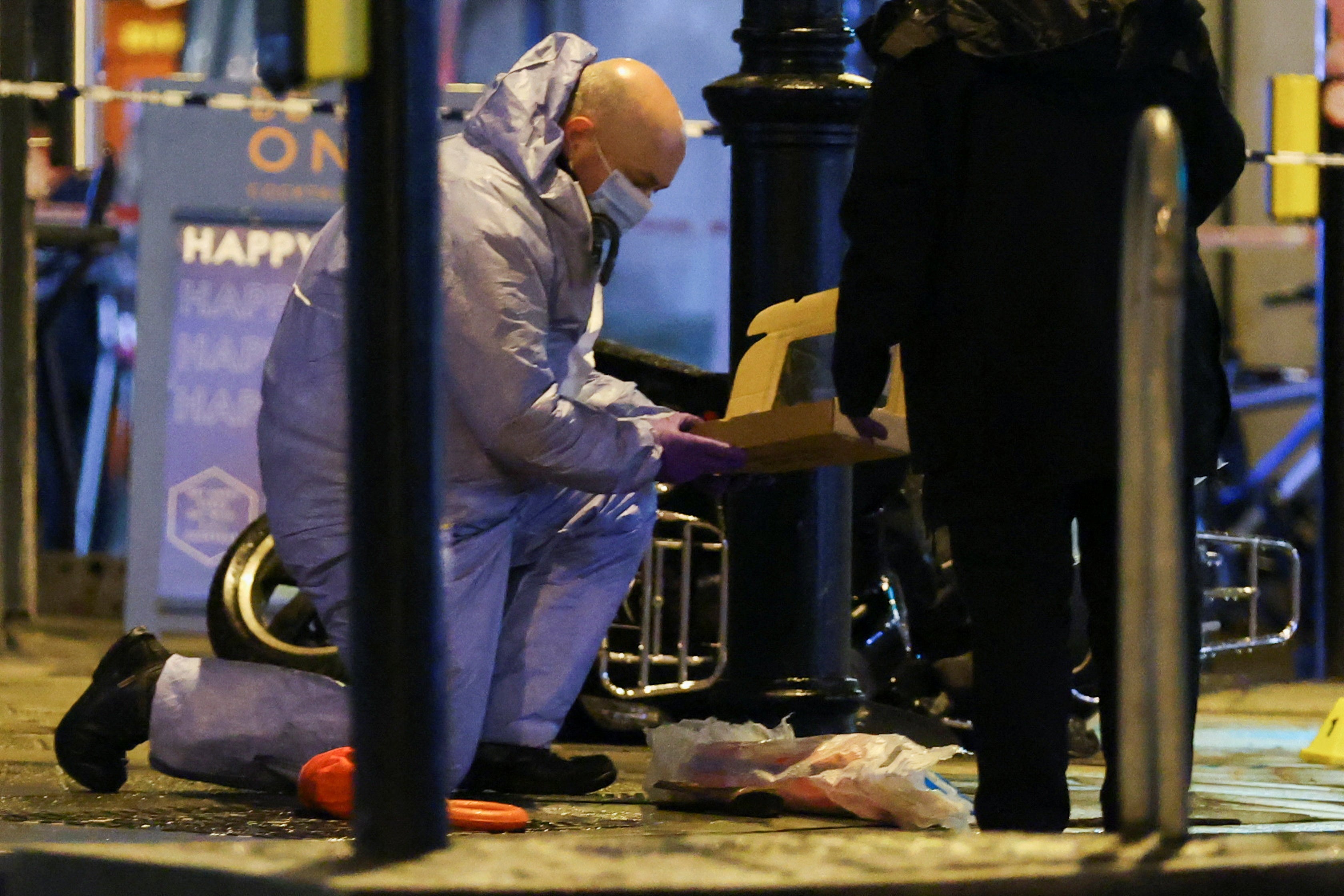 A police forensic officer works at the site of an incident in south London