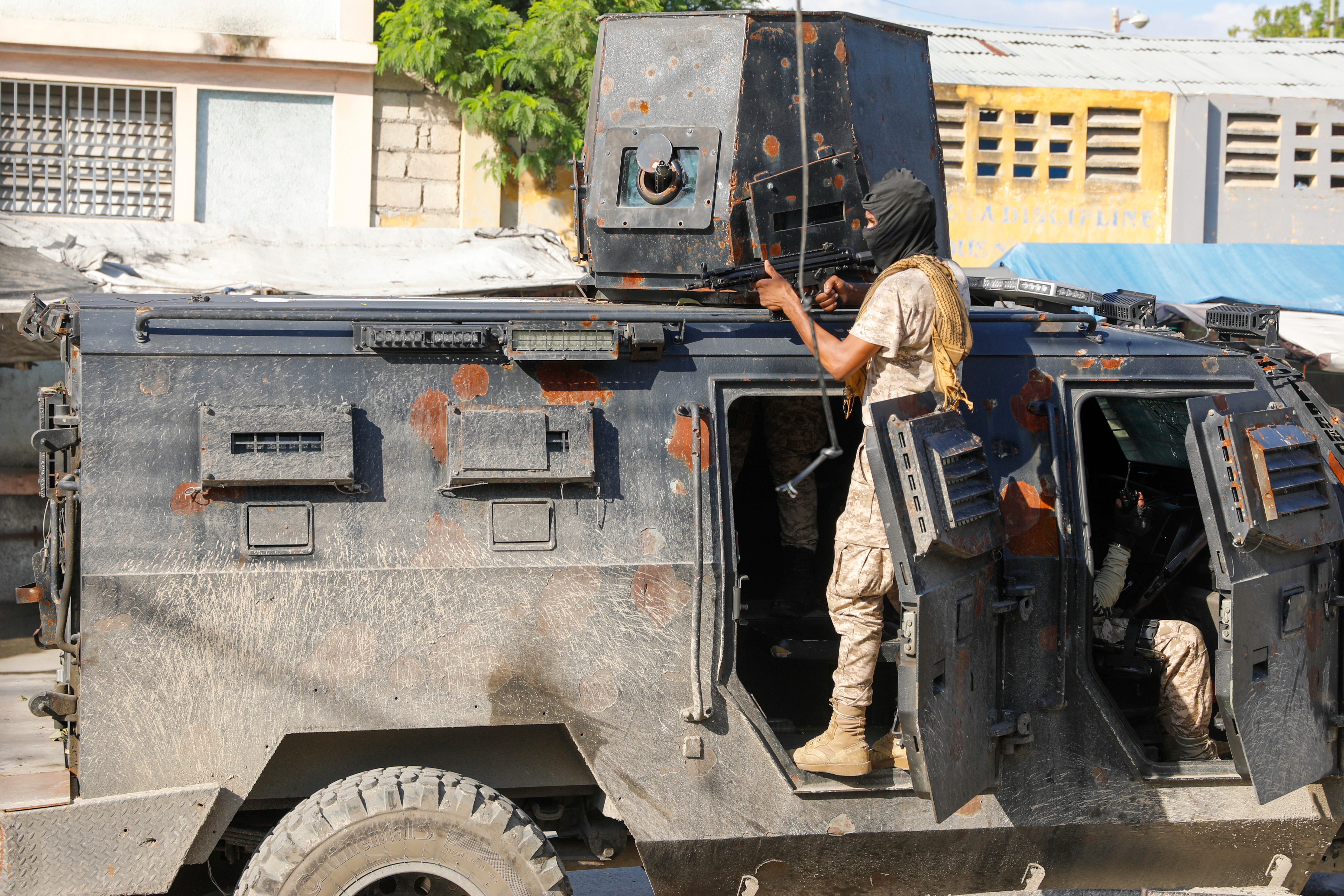 Police take cover during an anti-gang operation in Port-au-Prince