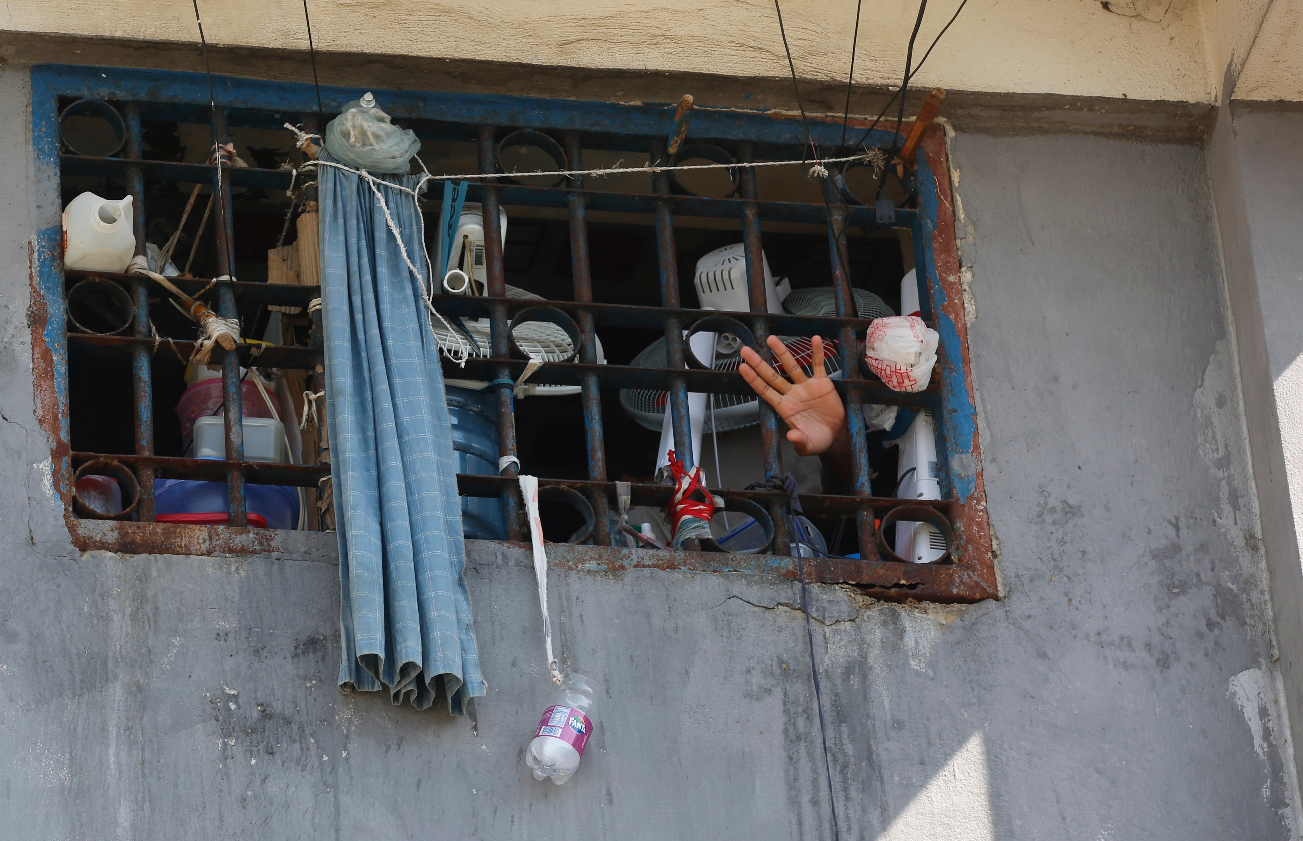 An inmate waves at the National Penitentiary in Port-au-Prince, Haiti, Sunday, March 3, 2024