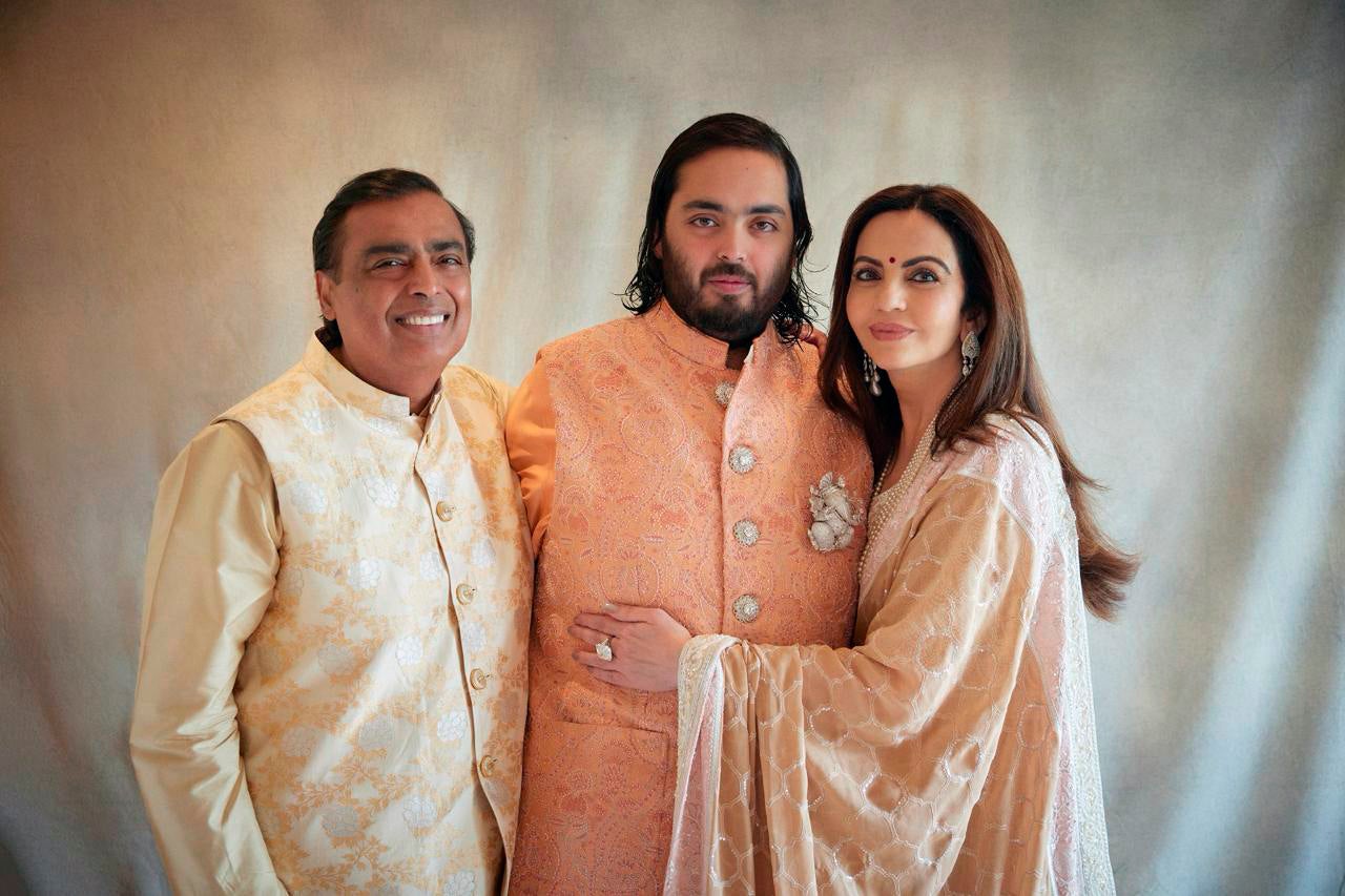 This photograph released by the Reliance group shows from L to R, billionaire industrialist Mukesh Ambani, son Anant and wife Nita, posing for a photograph as guests gather to celebrate Anant’s wedding in Jamnagar, India, Saturday, 2 March 2024