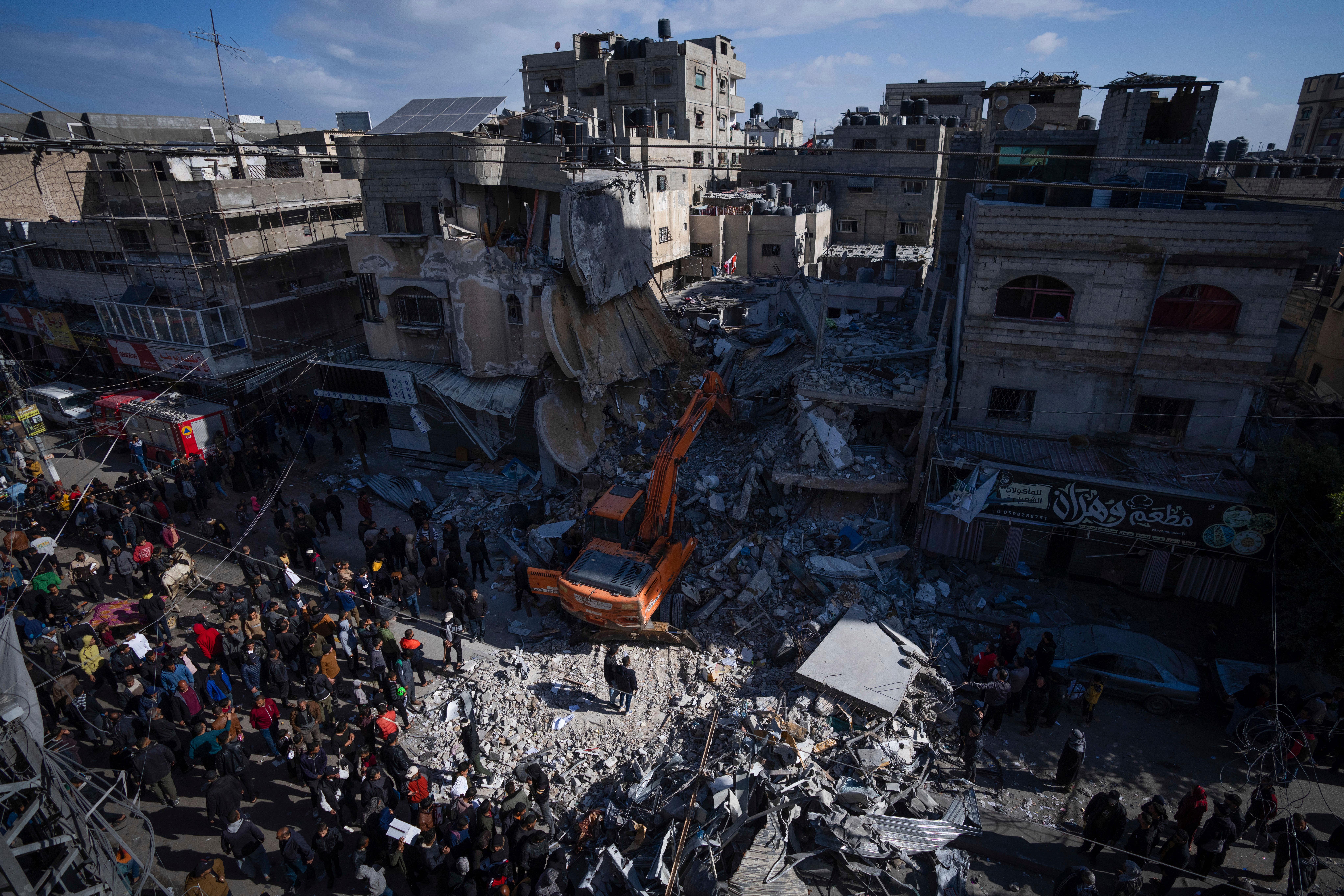 Palestinians search for bodies and survivors in the rubble of a residential building destroyed in an Israeli air strike in Rafah (AP Photo/Fatima Shbair)