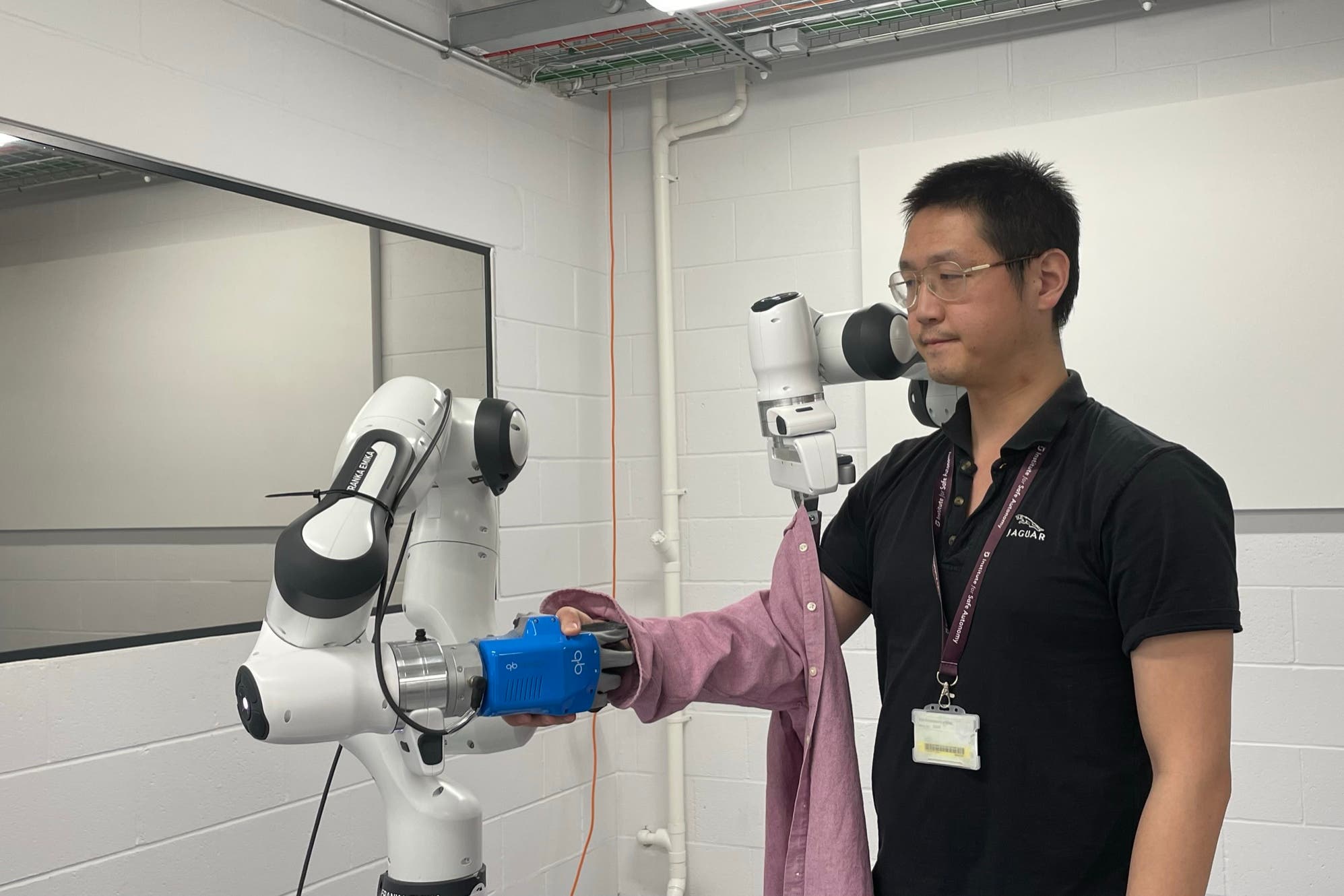 Dr Jihong Zhu testing out a robot dresser (University of York/PA)