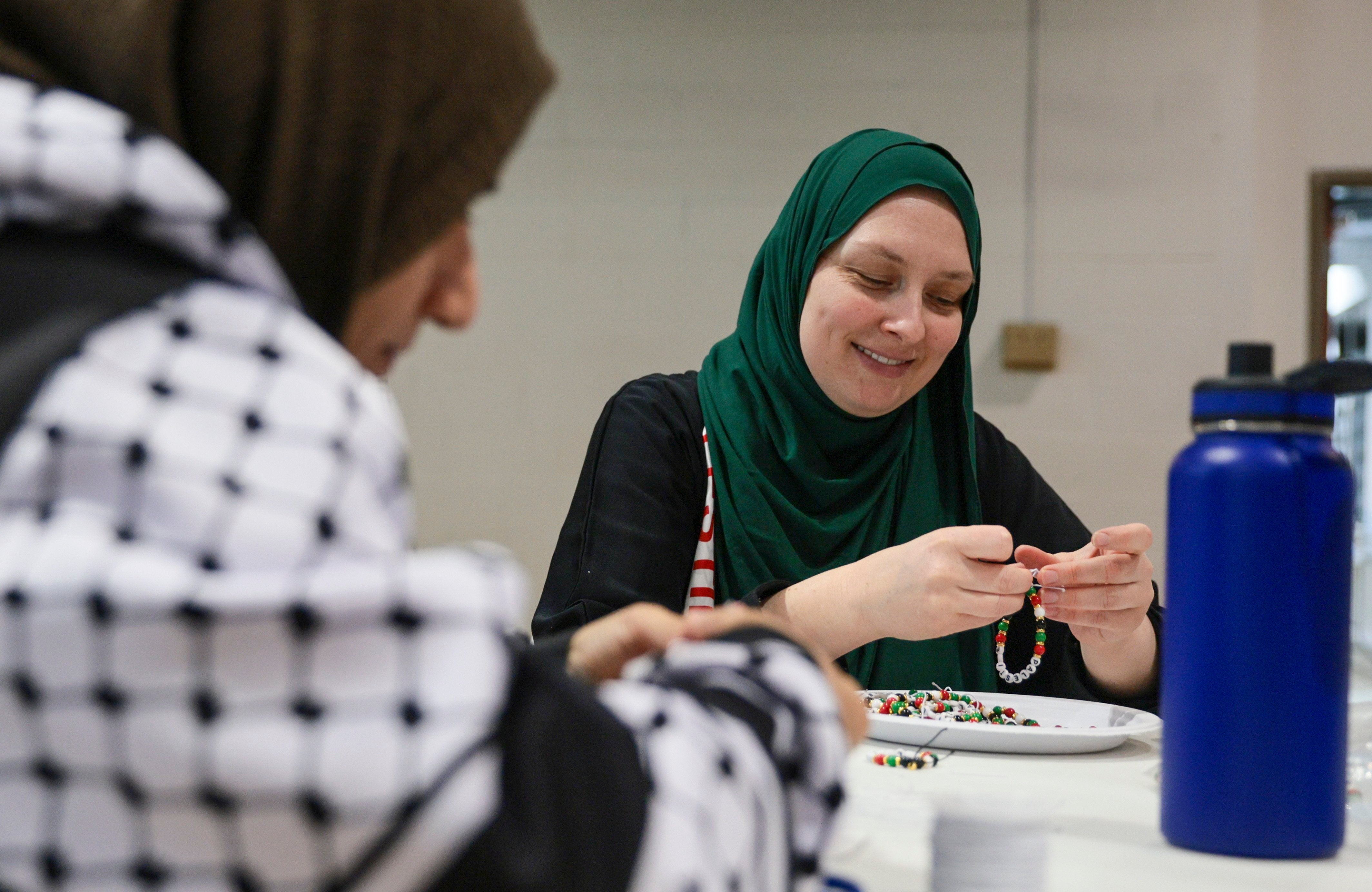 Melissa Saunders ties loose bracelets for her daughter’s fundraiser for children affected by the war in Gaza