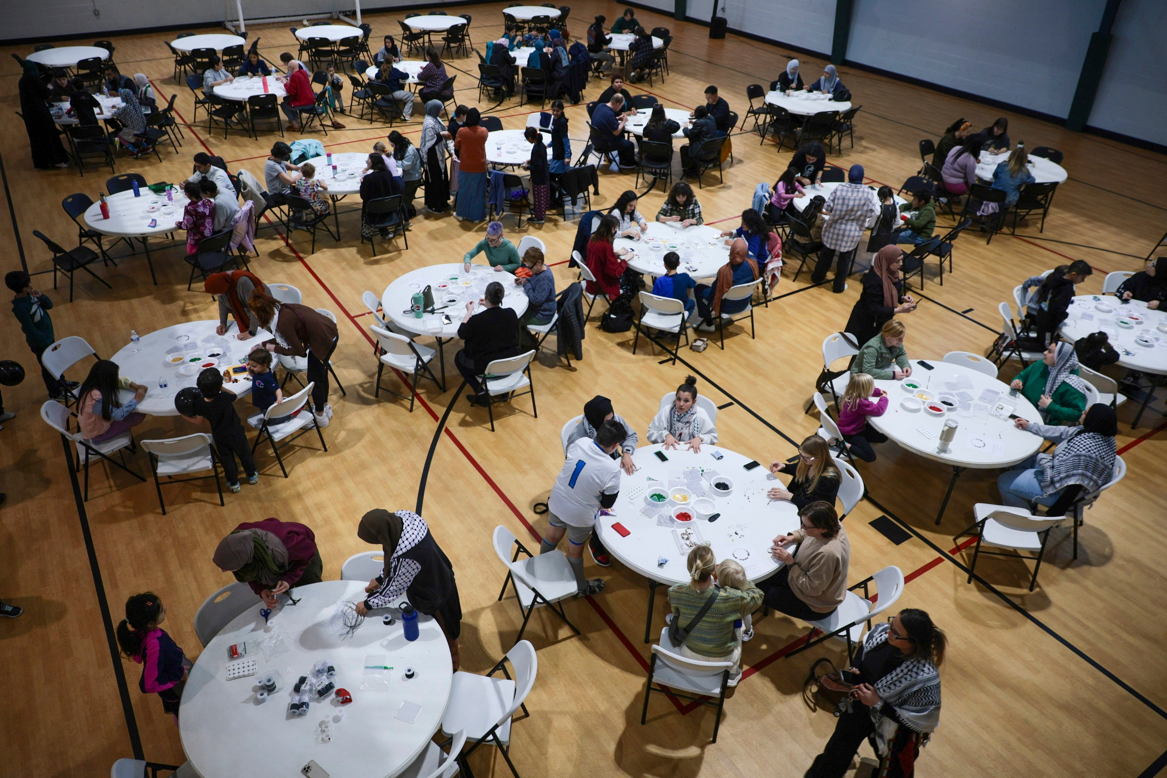 People gather to make bracelets with former Girl Scout Troop 149