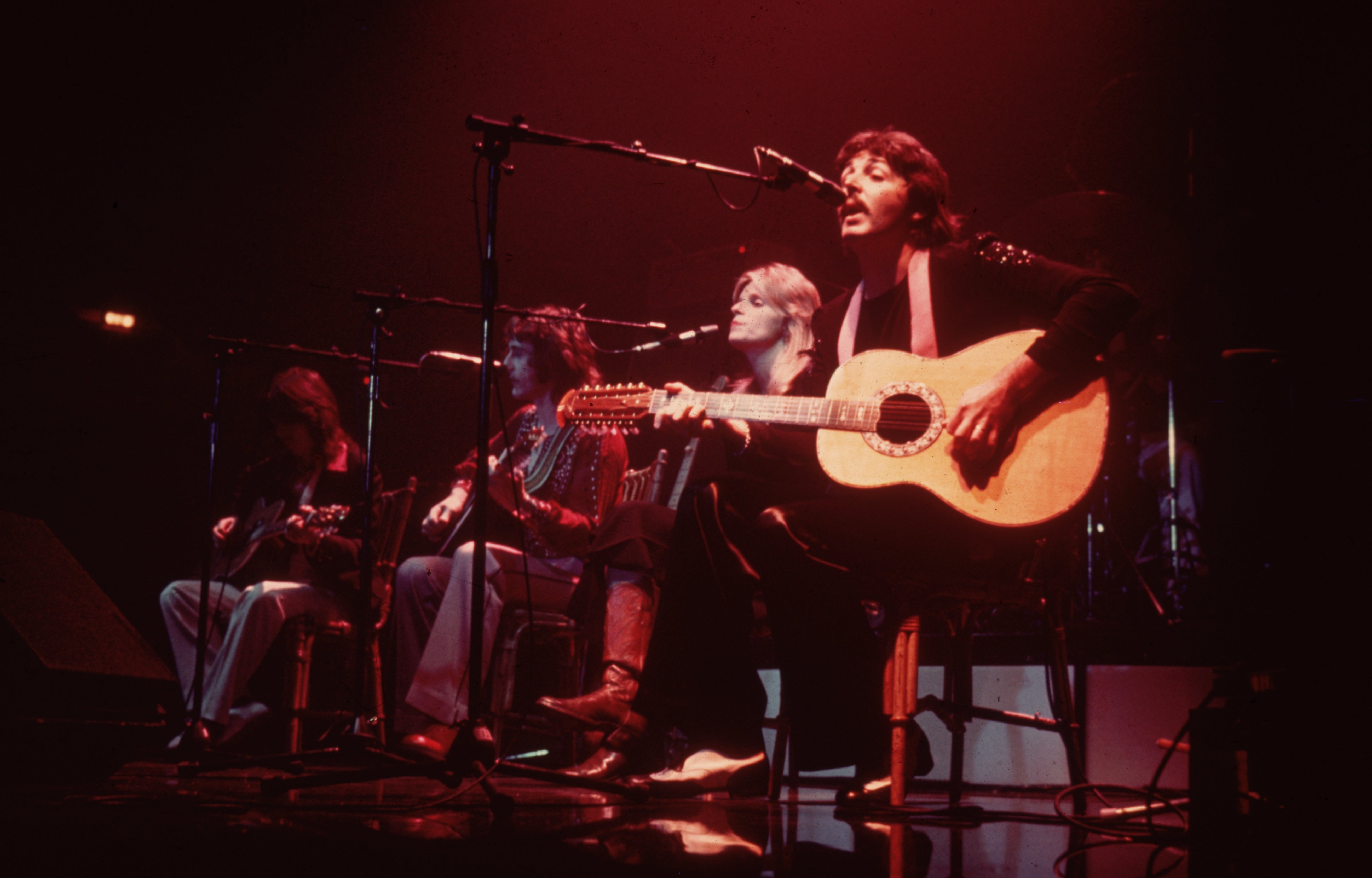 Paul McCartney on stage with his wife, Linda McCartney (1941-1998) as Wings perform at London’s Empire Pool in 1976