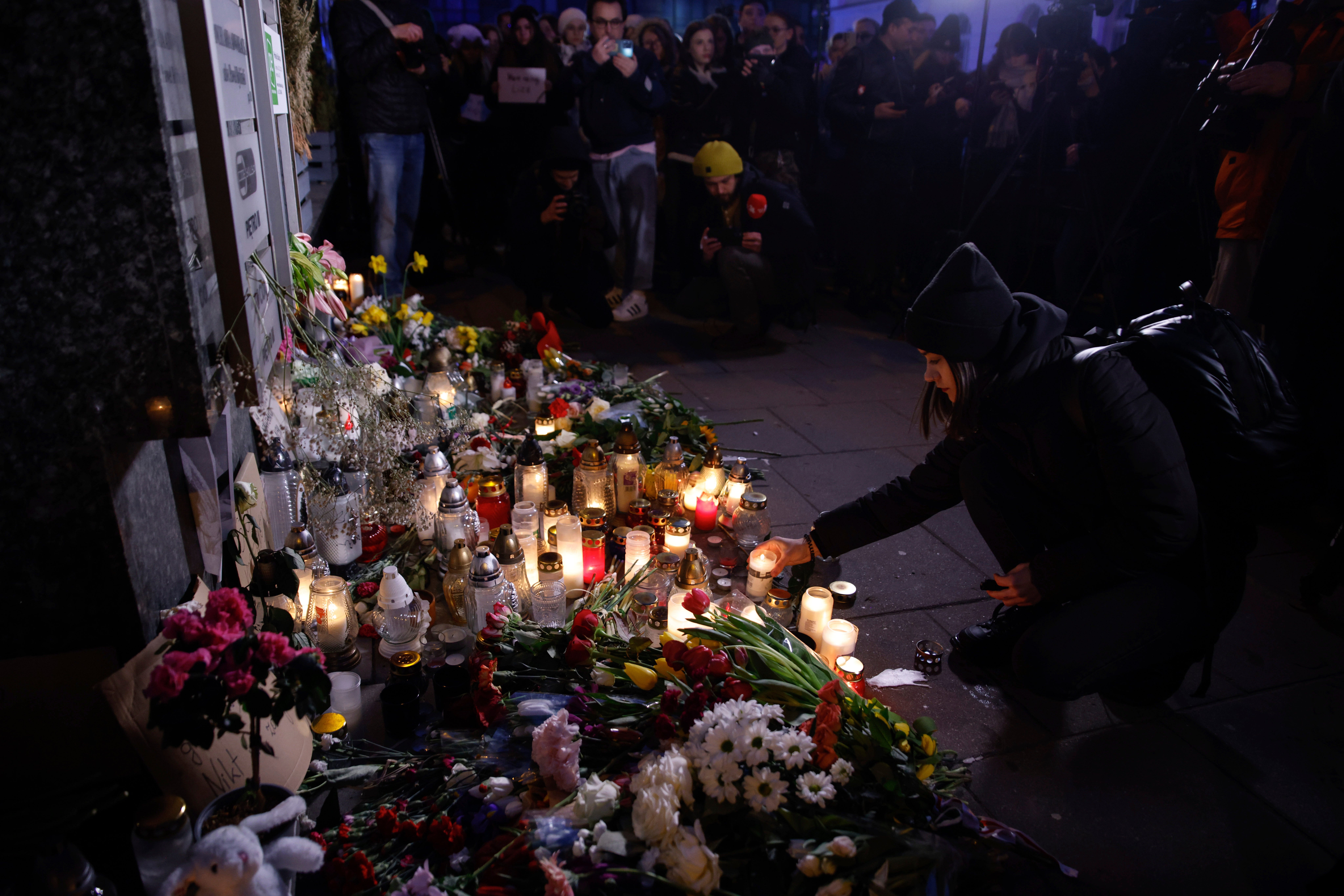 A woman lights a candle during a march in silence to commemorate Lizaveta, a 25-year-old Belarusian woman who was murdered in Warsaw